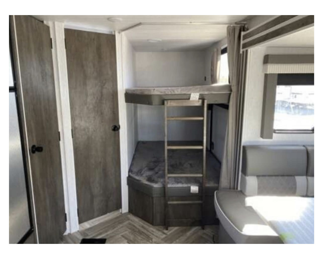Spacious RV rental interior features bunk beds with a ladder, a dinette, and two doors, ideal for travel.. Forest River Salem 26 DBUD 2023