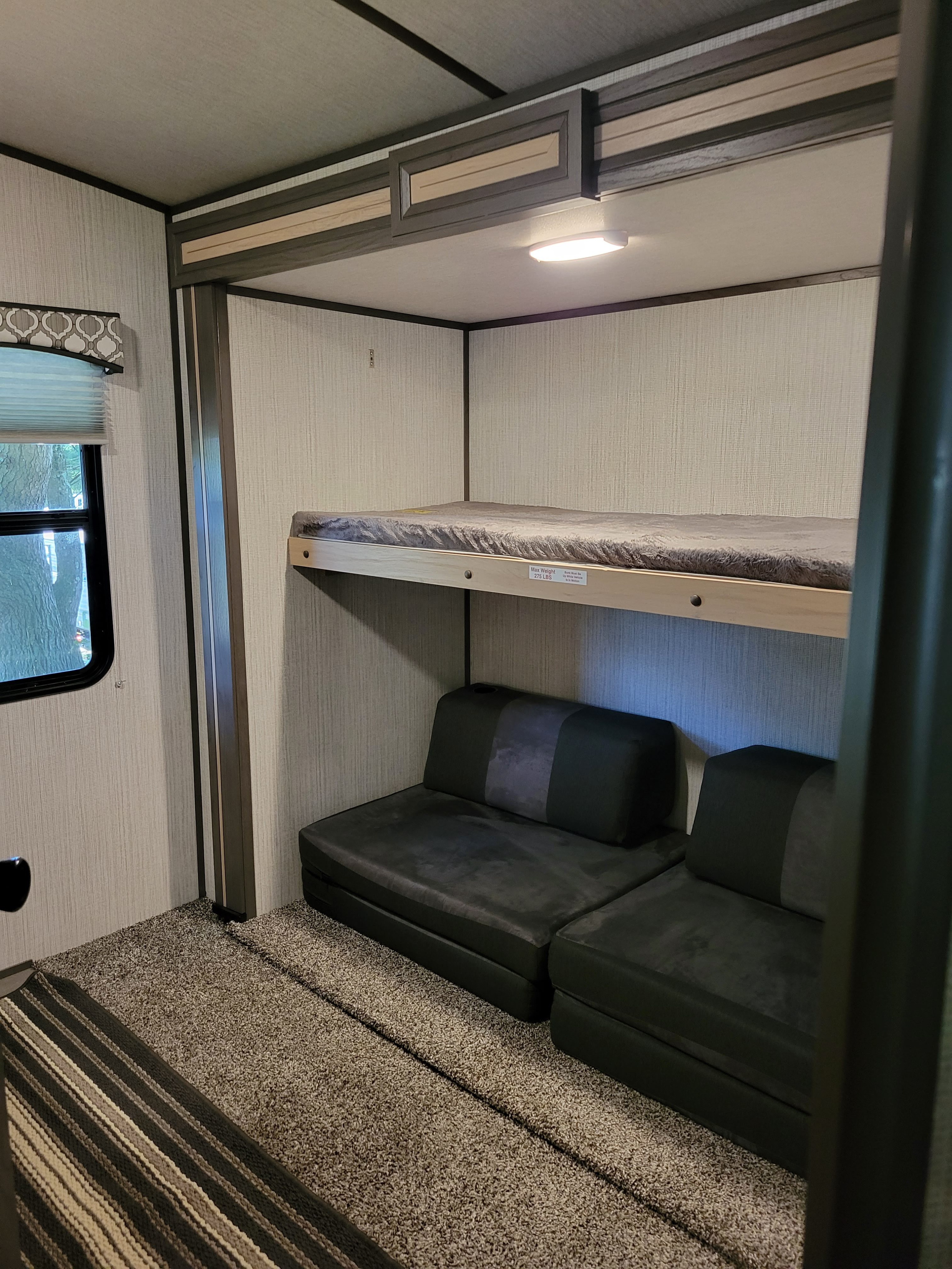 Inside this RV rental, find comfortable bunk beds over a versatile sofa, perfect for compact travel lodging.. Cruiser RV Radiance 2021