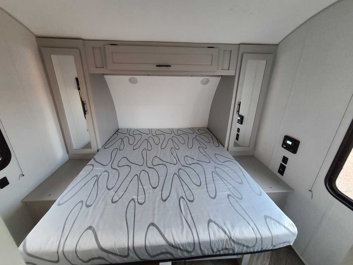 RV rental bedroom: Modern, compact interior with bed, overhead storage, and mirrored cabinets for comfort.. Forest River Salem FSX Platinum Toy Hauler 2021