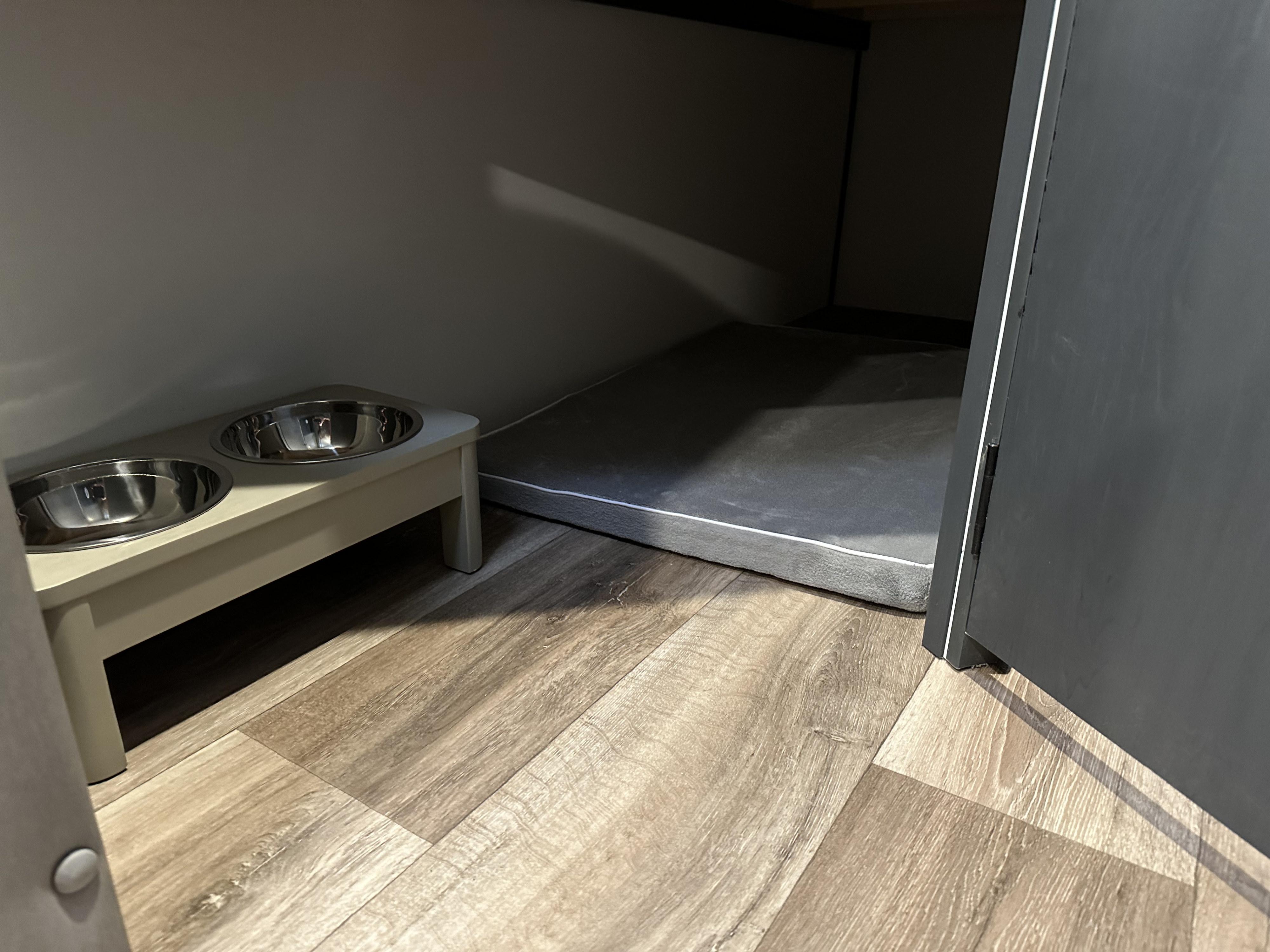 This cozy RV rental setup features a pet feeding station with two bowls and a comfortable grey dog bed for your furry friend.. Keystone RV Bullet Crossfire 2022