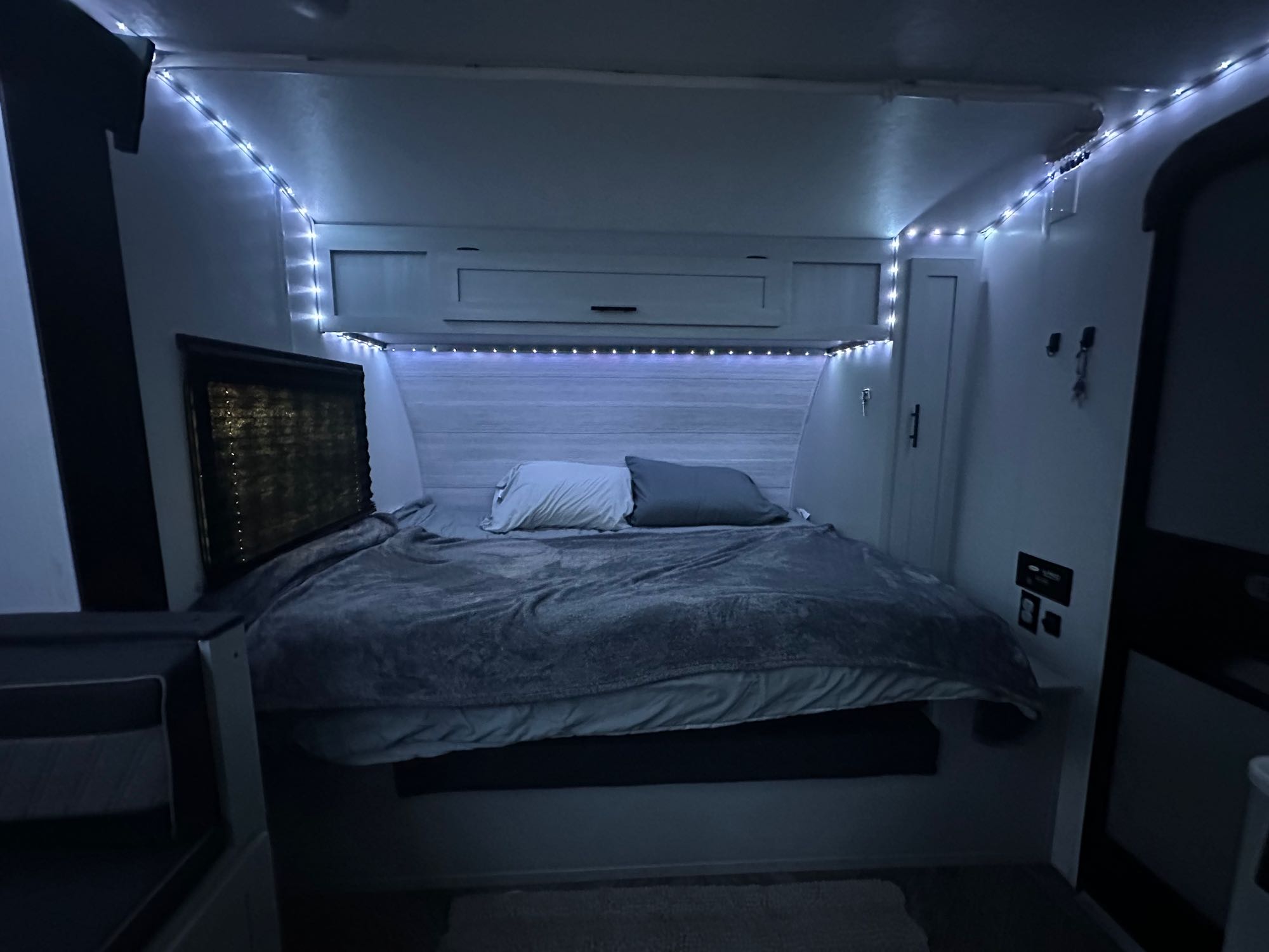 Cozy RV rental bedroom with ambient LED lights, a comfortable bed, and convenient overhead storage.. Forest River Salem FSX 2022