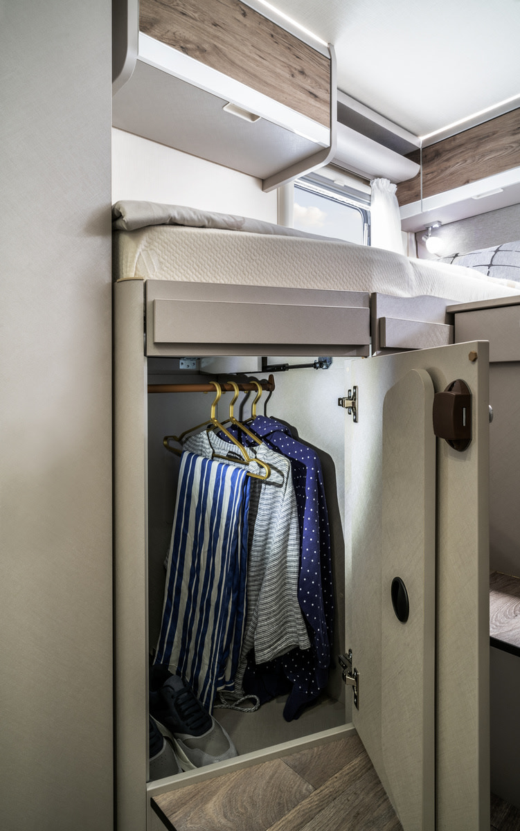 Compact RV rental: Wardrobe with clothes & shoes, elevated bed, and overhead cabinets. Smart storage for travel.. Hymer Exis I 678 2024