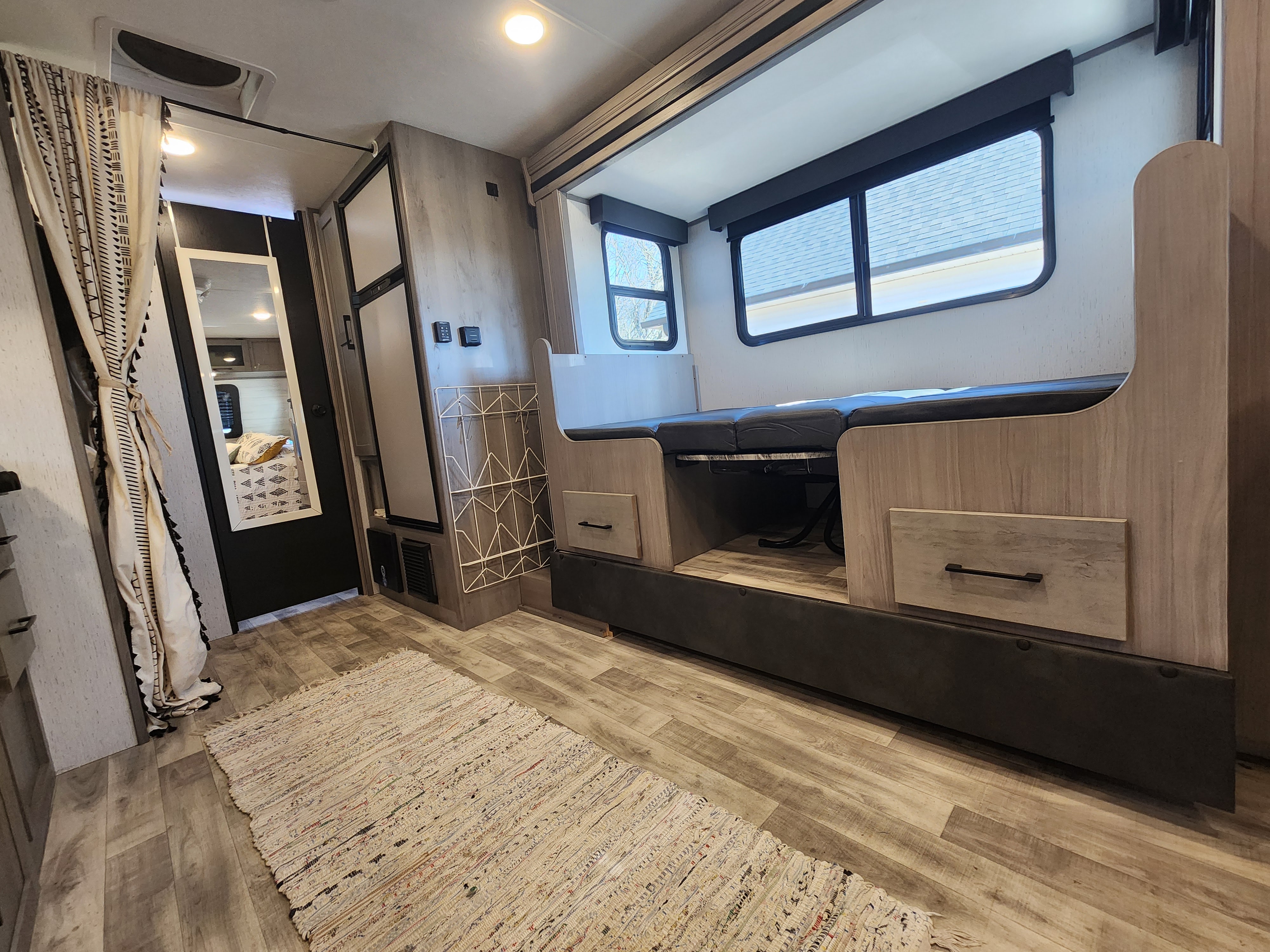 Cozy RV rental interior featuring bunk beds, storage, a fridge, and a mirror, perfect for compact travel living.. Dutchmen Kodiak Cub 2022
