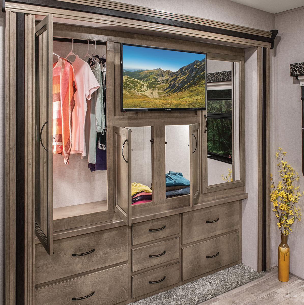 RV rental: Modern built-in storage with hanging closet, TV, and drawers. Mirror shows nature.. K-Z Manufacturing Durango 2017