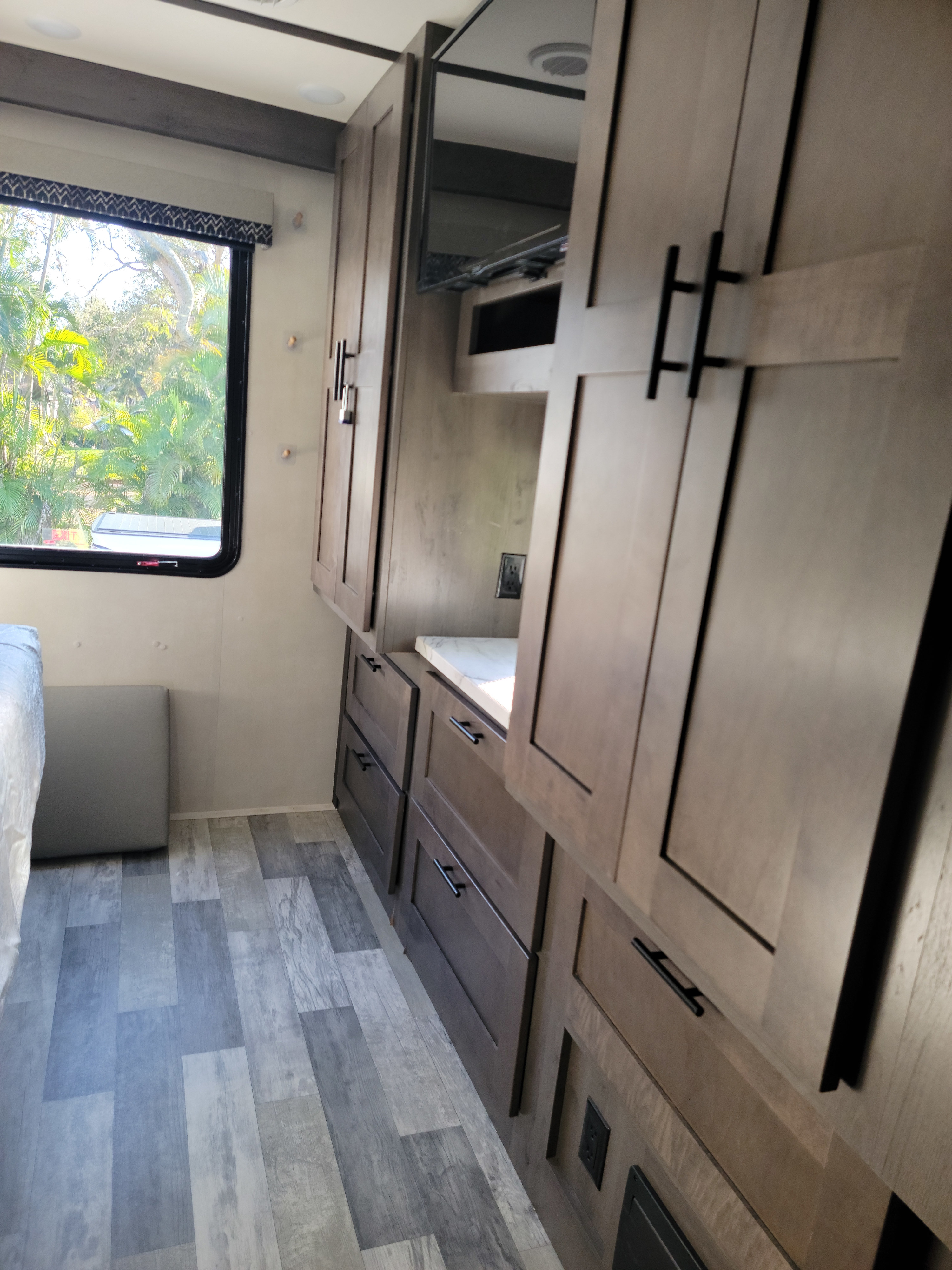 Modern RV rental interior: bedroom area with ample storage, TV, and scenic window view.. FR3 FR3 Motorhome 2022