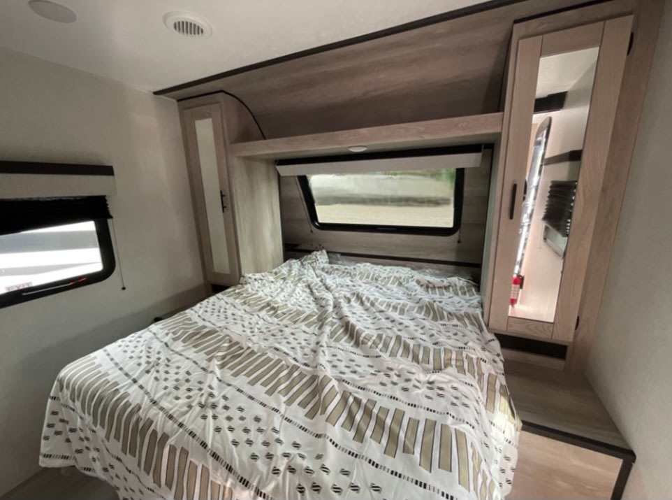 Step inside this inviting RV rental bedroom with a comfy bed, clever storage, and dual windows for views.. KZ C312BHKSE 2022