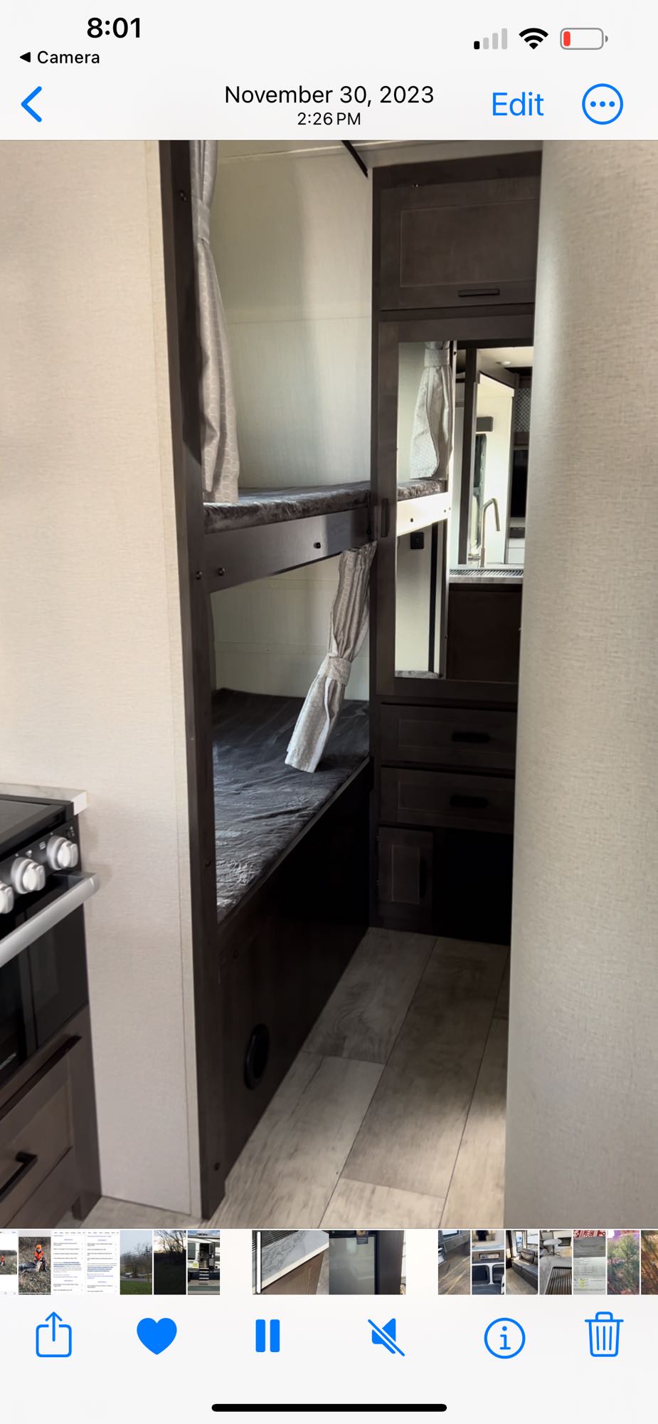 Cozy RV rental interior featuring dark wood bunk beds with privacy curtains and a compact kitchen area.. Grand Design 29 Go Momentum Toy Hauler 2021