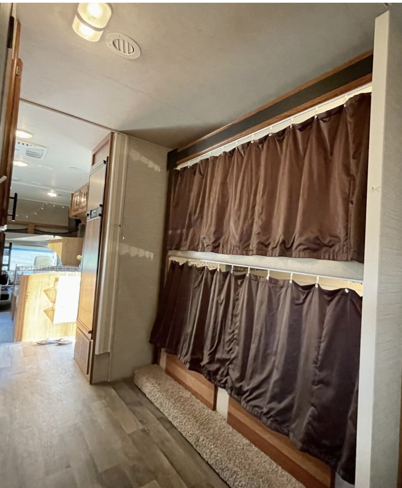 Inside this RV rental: comfortable bunk beds with privacy curtains, a bright living space, and wood flooring.. Jayco Redhawk 2017