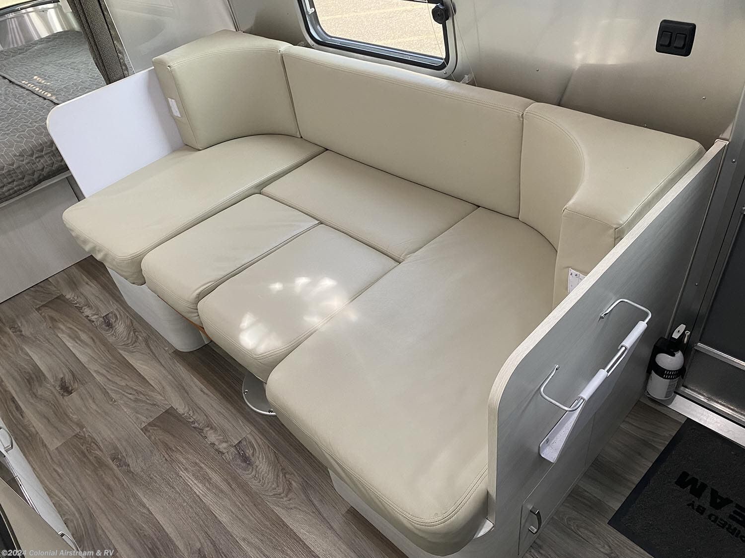 Airstream RV rental interior: Light cream U-shaped dinette seating, wood-look floor, and versatile lounge space.. Airstream Sport 2019