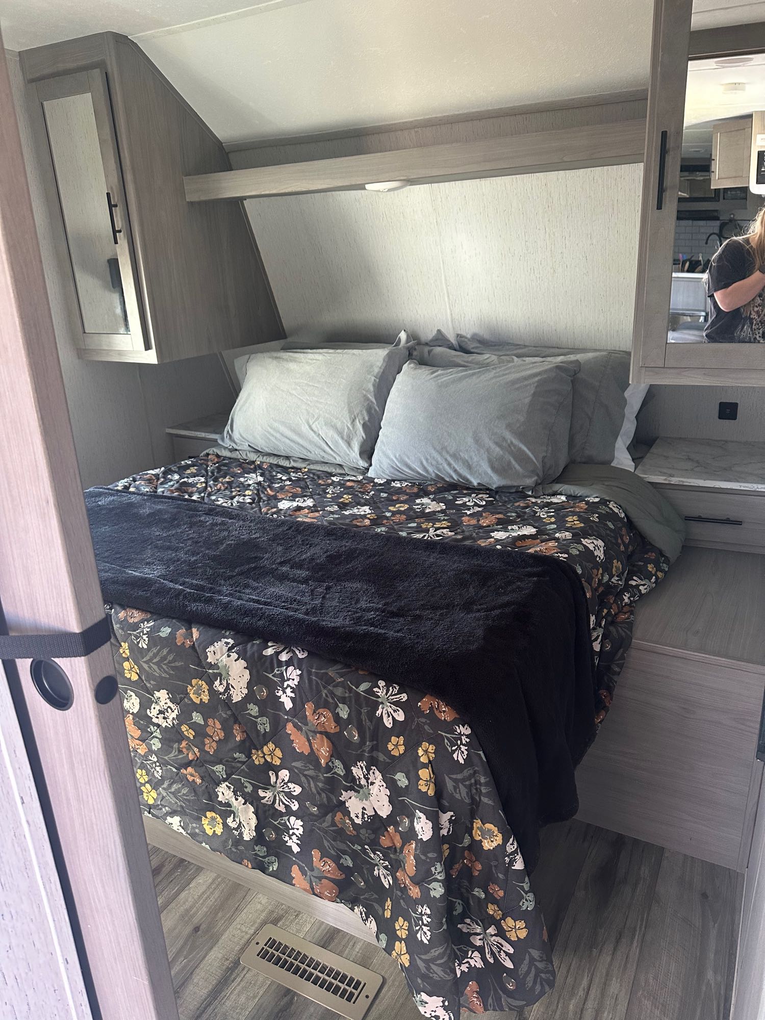 Cozy RV rental bedroom with floral bedding, built-in storage, and compact design. Perfect for your next adventure.. Dutchman Coleman Lantern 2022
