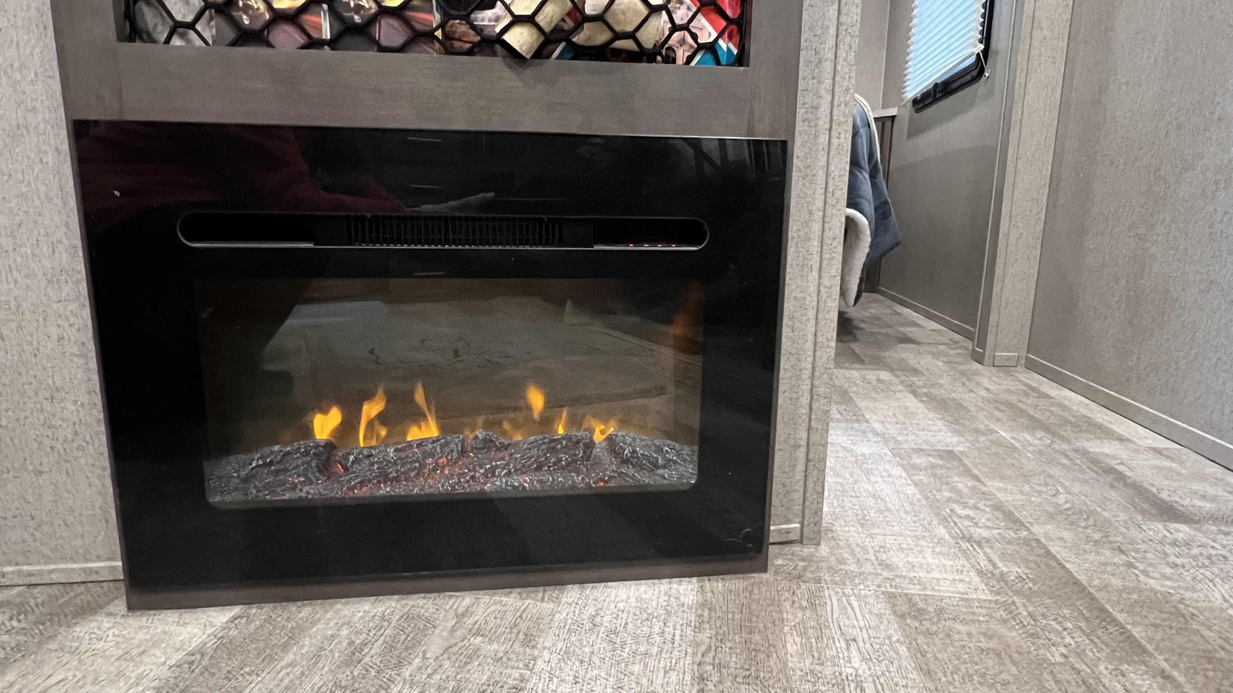 Cozy RV rental interior featuring a modern electric fireplace with realistic faux flames and logs for a warm ambiance.. Forest River Rockwood Mini Lite 2021