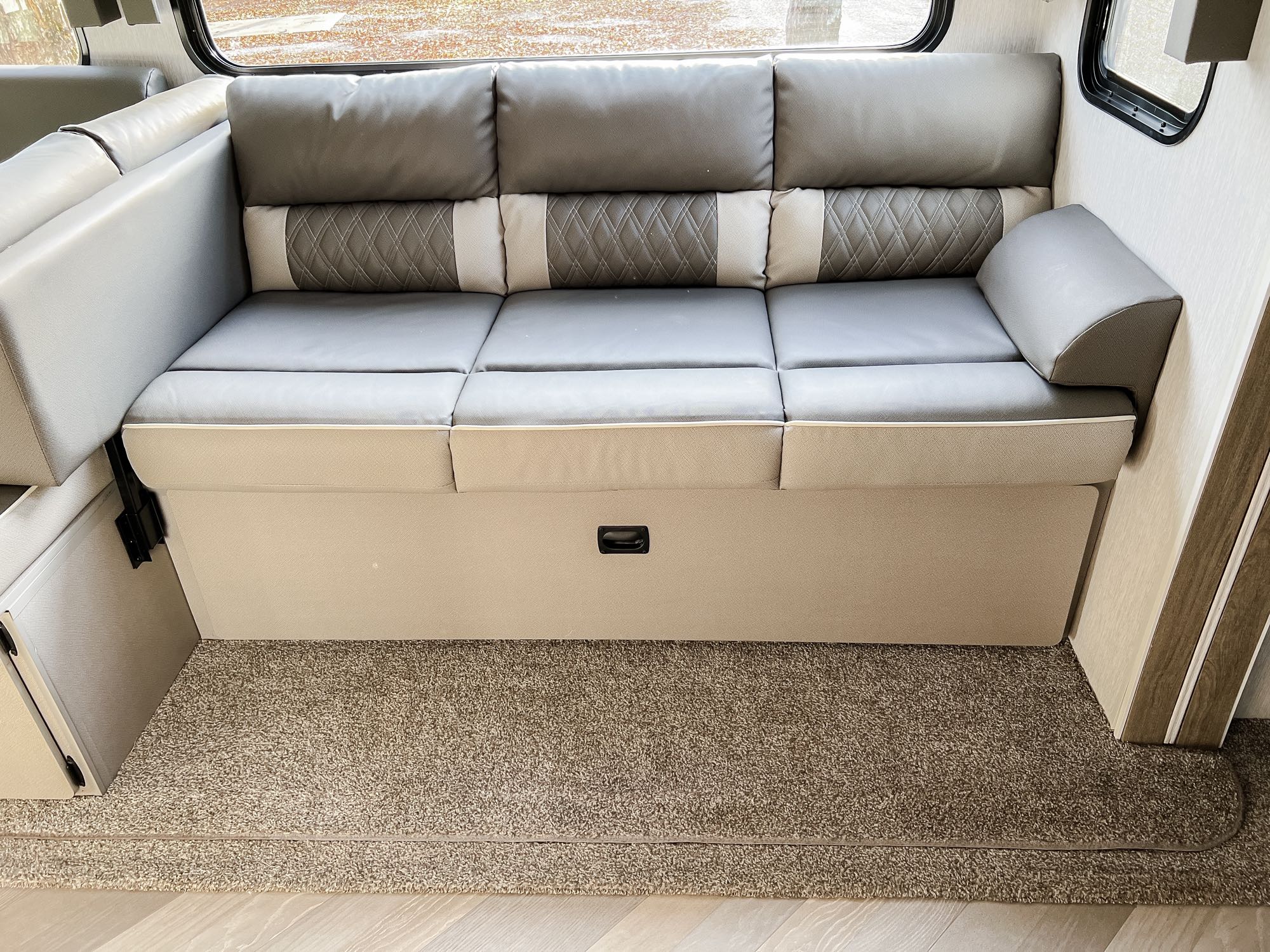 RV rental: Modern gray sofa with patterned backrests & storage. Comfortable seating for travel adventures.. Forest River Salem 2022