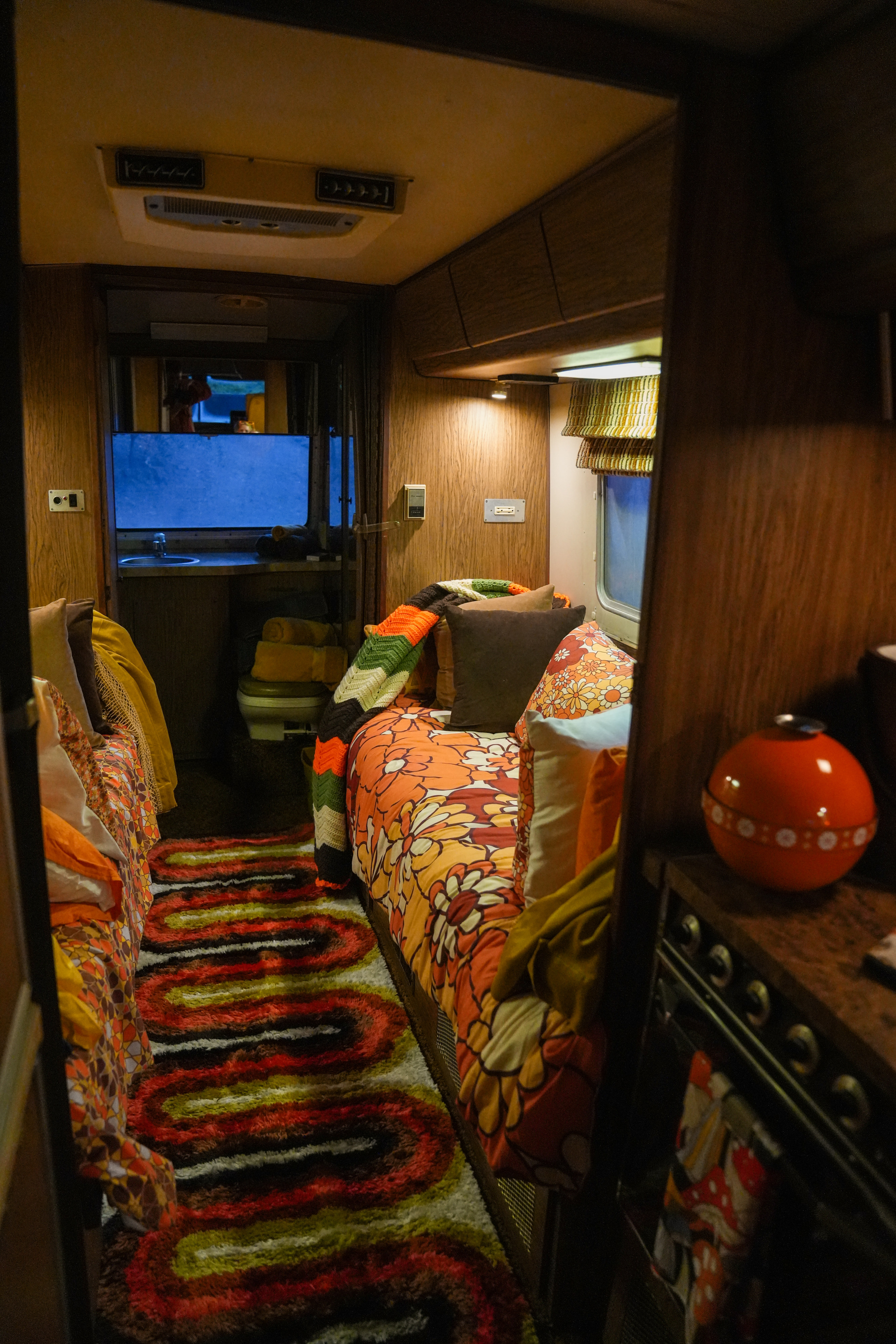 Explore this colorful rv rental's retro interior. Floral bedding, a swirling shag rug, & a cozy kitchen area in a vintage camper.. Revcon Buckingham 290 1977