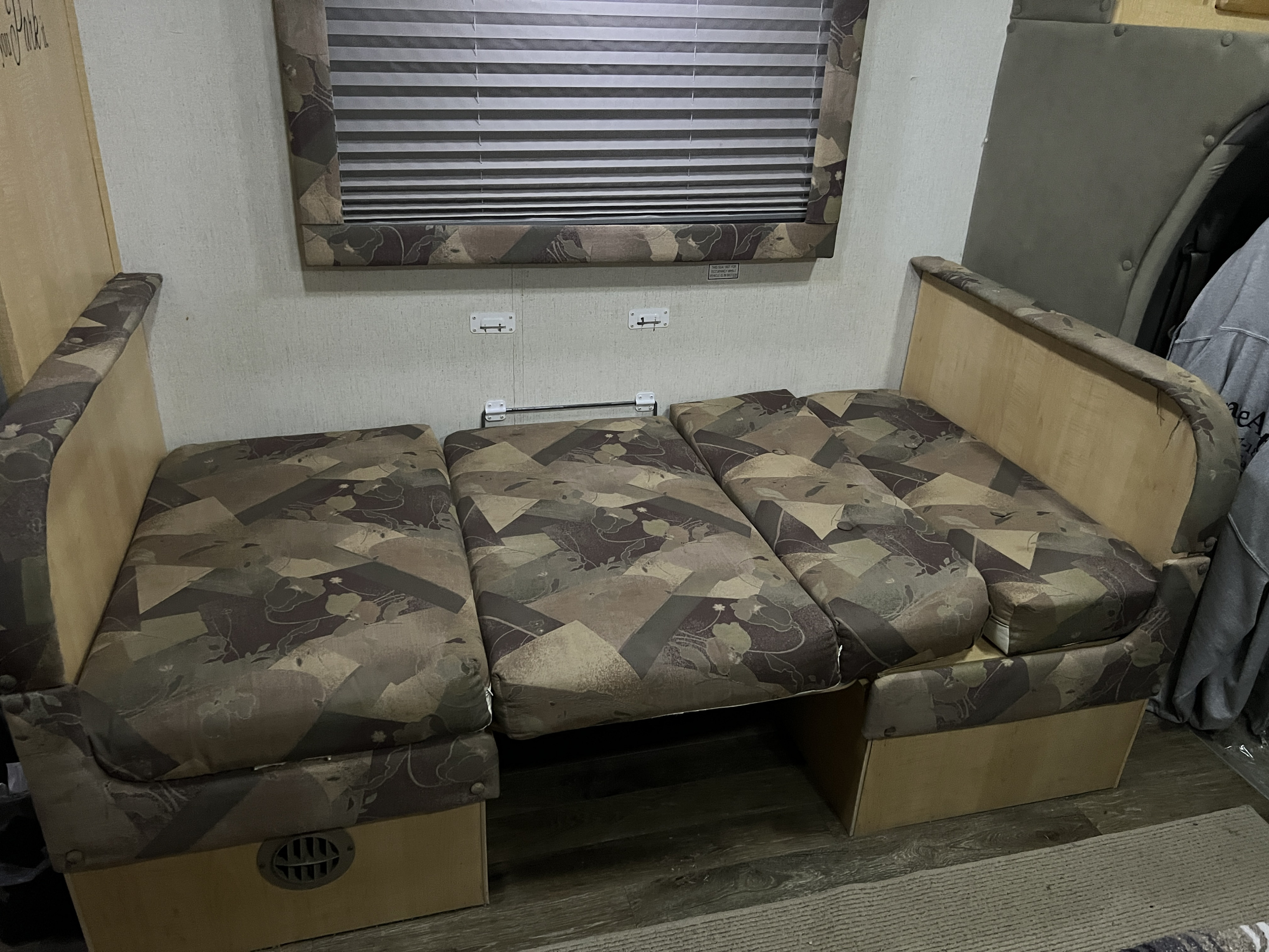 RV rental interior showing a convertible dinette bed with patterned cushions, providing comfortable sleeping space.. R-Vision Trail-Lite B-Plus 2004