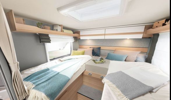 This light-filled RV rental bedroom features two comfortable beds, overhead storage, and a skylight, ideal for travel.. Dethleffs Just T6812 EB 2024