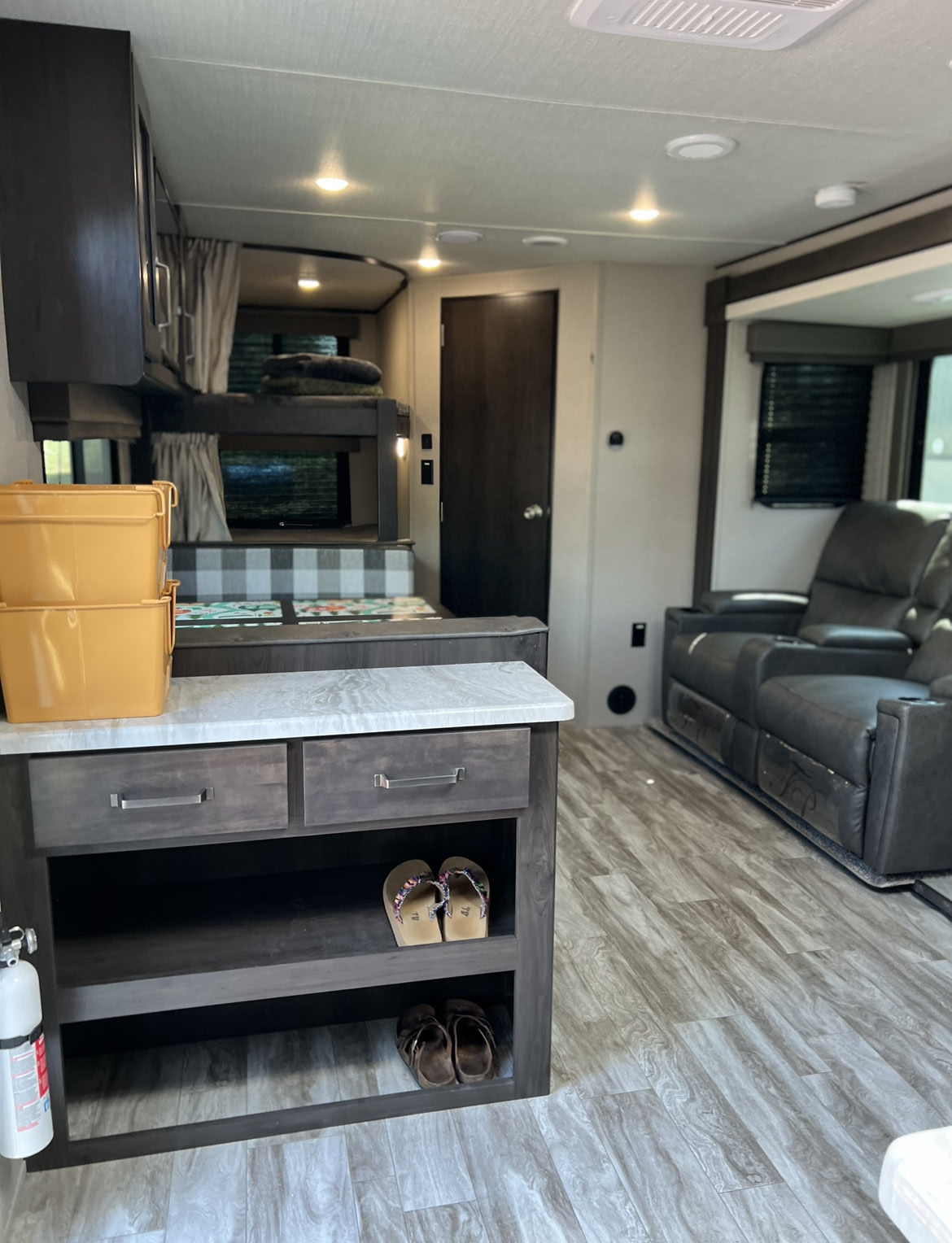 Spacious RV rental interior: features bunk beds, recliners, and a convenient shoe rack.. Grand Design Transcend Xplor 2022