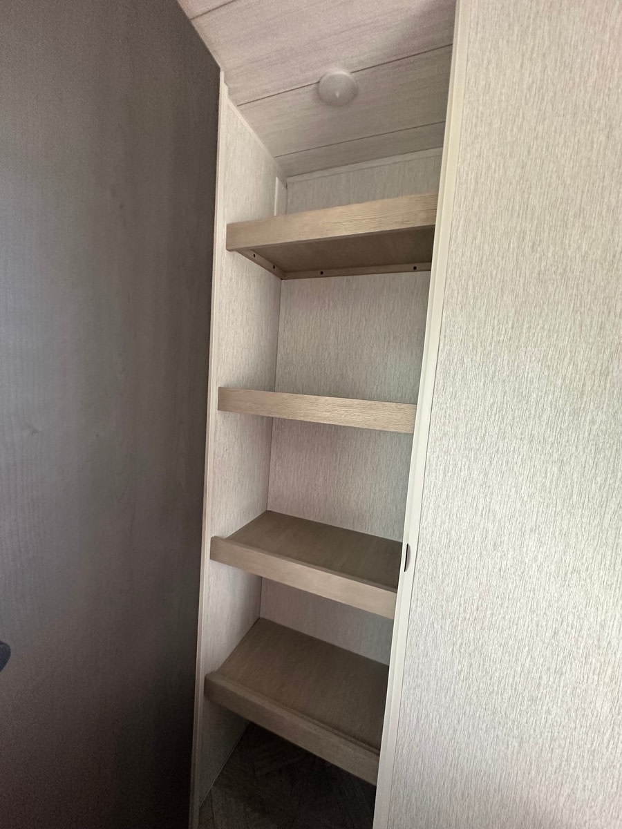 RV rental interior features light-toned built-in shelves with four levels for storage, illuminated by an overhead light.. Forest River Salem Platinum 2024