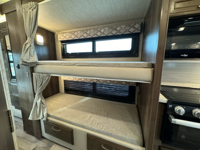 This RV rental offers a well-designed interior with comfortable bunk beds, privacy curtains, and a compact kitchen.. Jayco Redhawk 2022