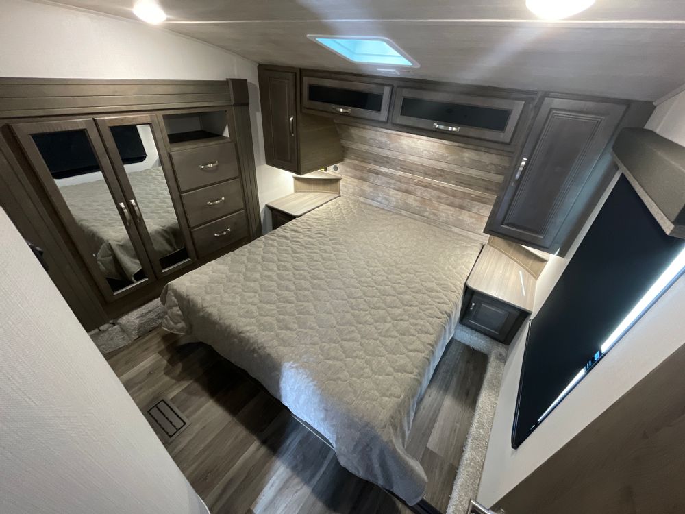 Spacious RV rental bedroom with a comfy bed, mirrored closet, and ample storage, perfect for your next adventure.. Other Other 2024