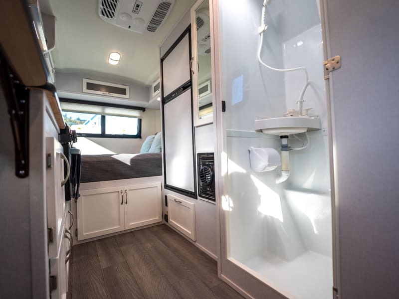 Clean RV rental interior shows compact kitchenette, rear bed, and a bright bathroom with shower, sink, and toilet paper.. Escape Trailer Escape Trailer Trailer 2023