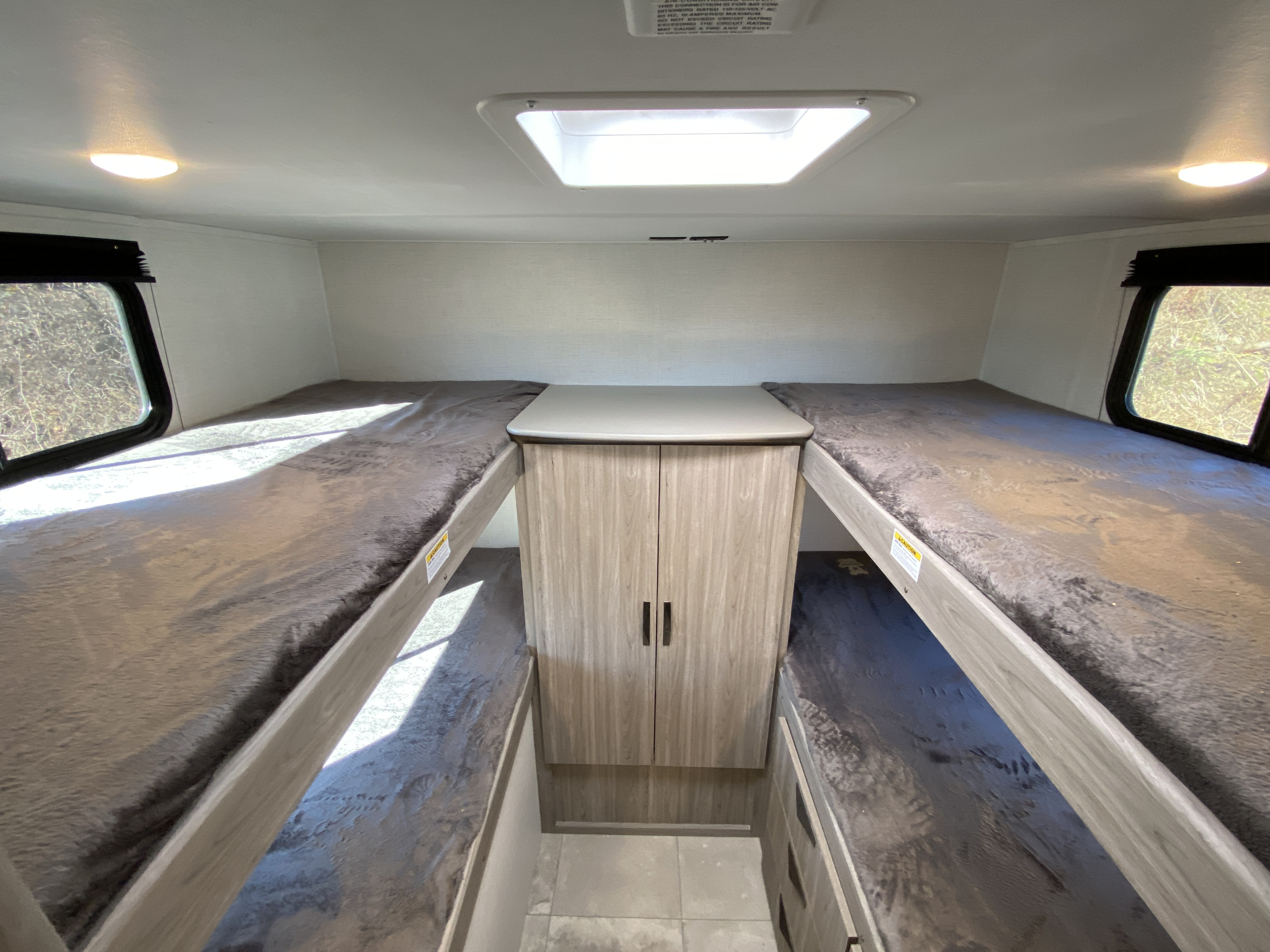 RV rental: Interior with two sets of bunk beds, central cabinet, windows, and skylight.. Keystone RV Passport 2024