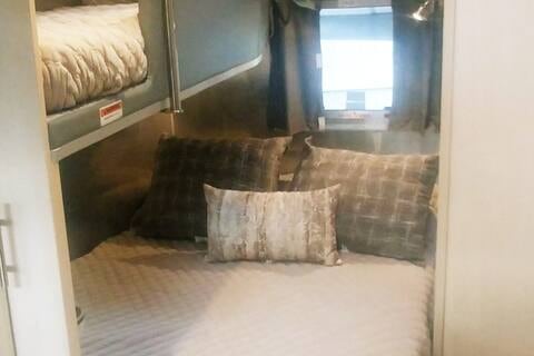 Cozy RV rental bedroom with a comfortable bed and bunk, perfect for family travel.. Airstream Flying Cloud 2022