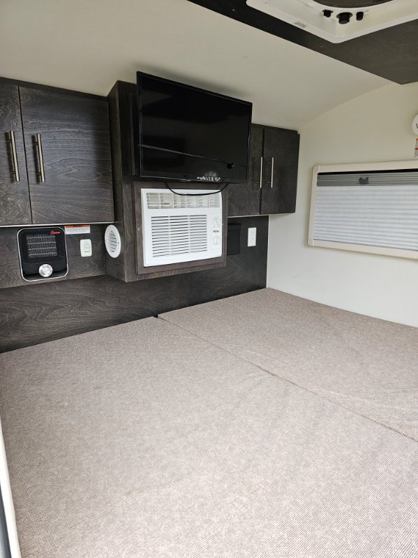 Experience an RV rental! Compact interior with bed, TV, AC unit, heater, and sleek storage cabinetry.. nuCamp T@G 2021