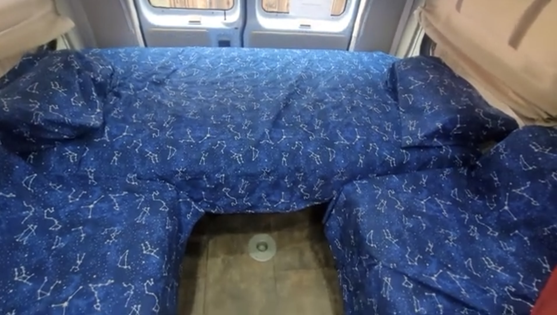 RV rental interior featuring a unique blue constellation-patterned bed setup, ideal for a comfortable van life experience.. Pleasure-Way Excel TS 2012