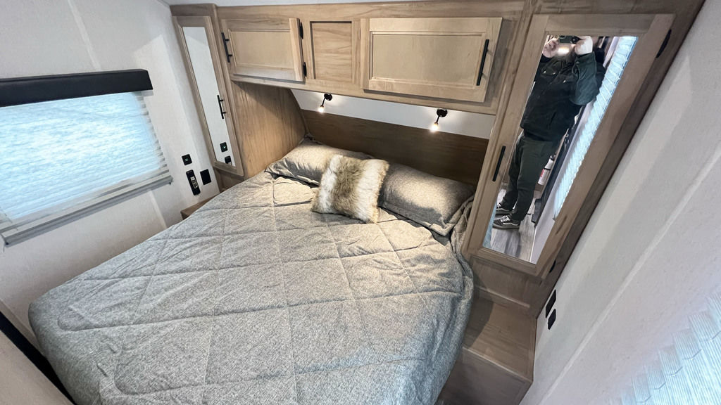Comfortable RV rental bedroom with a cozy bed, overhead cabinets, and window. Ideal for your next road trip.. Forest River Cherokee Grey Wolf Black Label 2023