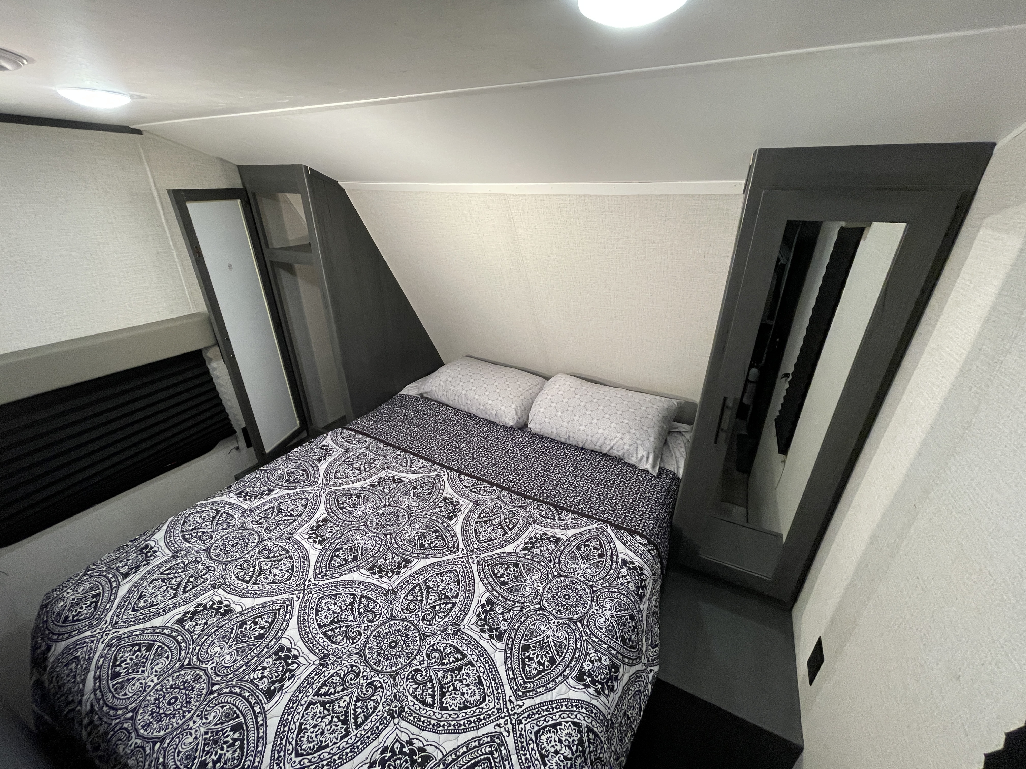 This RV rental offers a compact yet comfortable bedroom with a decorative bed, pillows, and integrated storage.. Dutchmen Colorado 2023