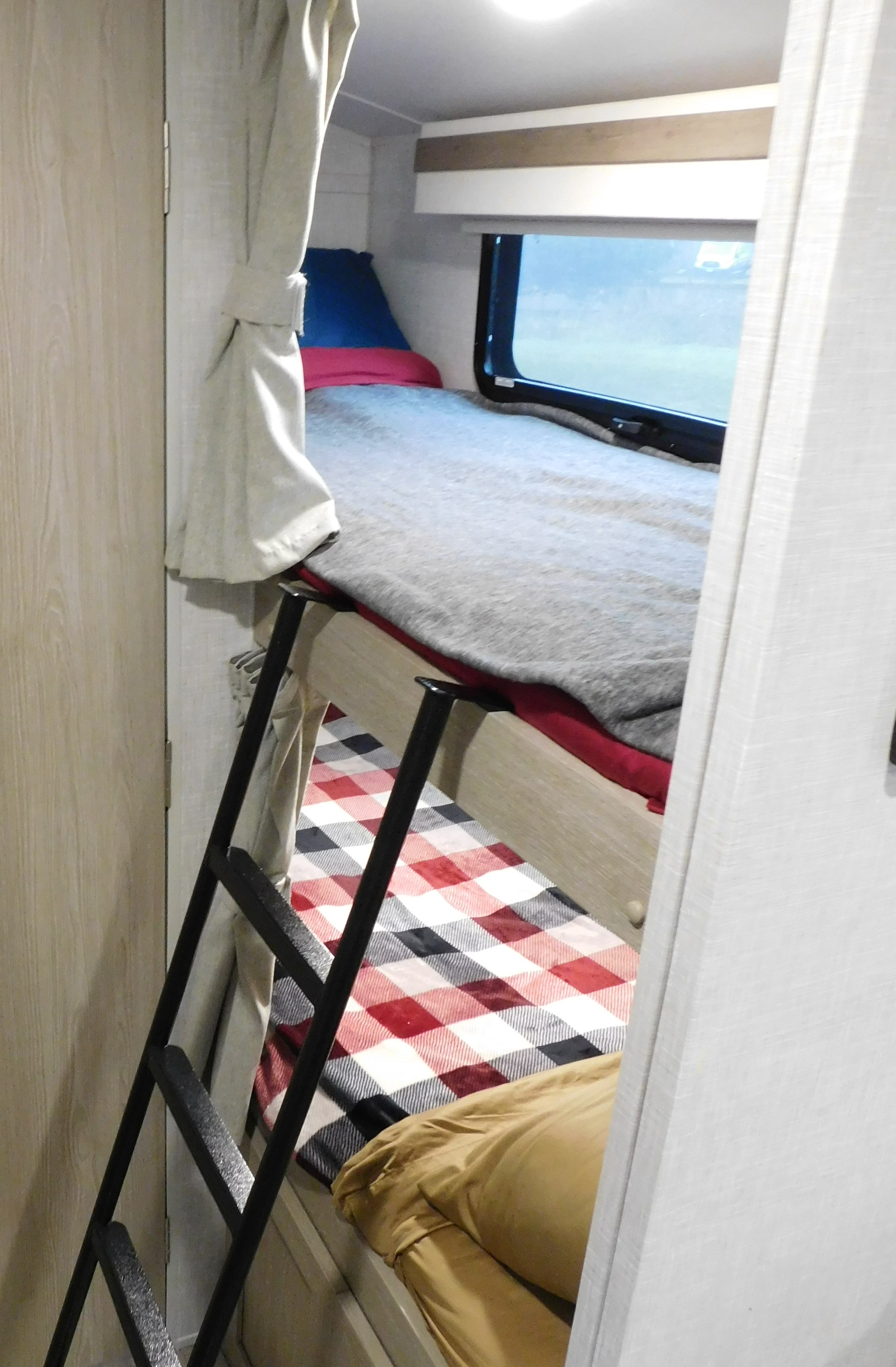 RV rental with two bunk beds, a ladder, window, and cozy bedding. Curtains provide privacy.. Forest River GeoPro 20BHS 2022