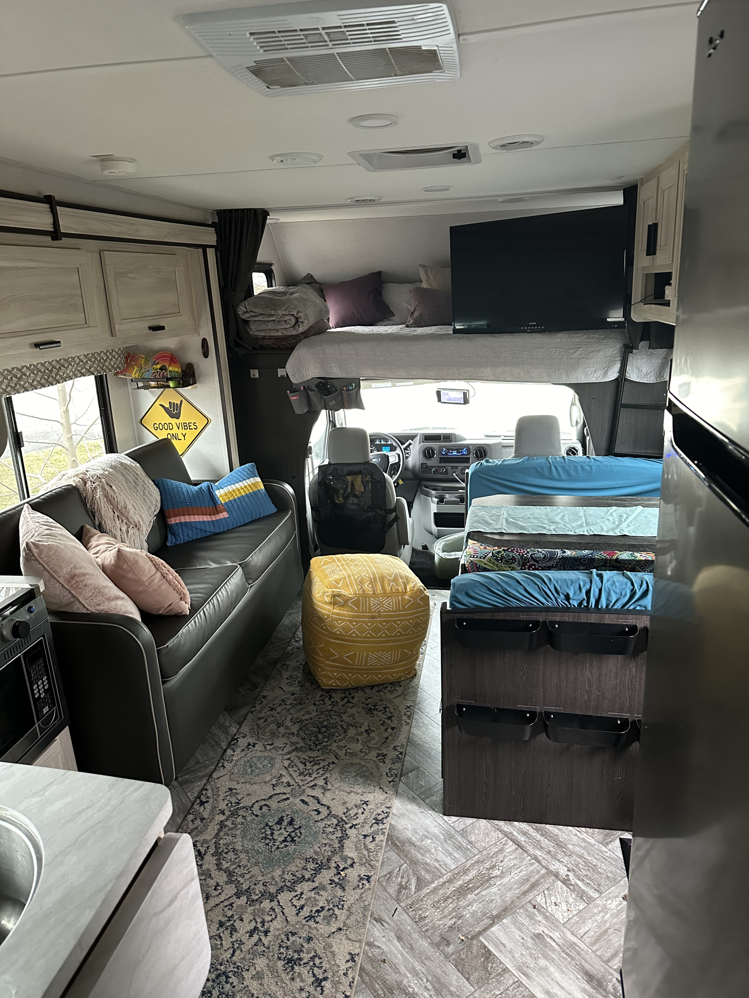 This RV rental interior features a cozy living space, cab-over bunk, kitchenette, and driver's area for comfortable travels.. Forester LE 2022