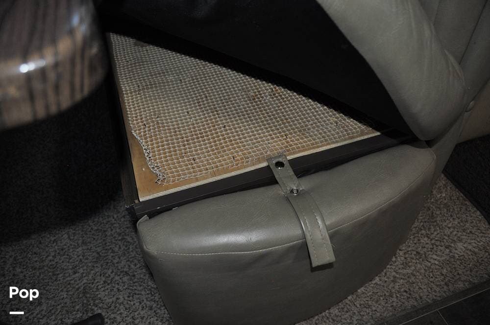Lifted RV rental seat cushion reveals under-seat storage with a non-slip mat, ideal for hidden compartment needs.. Keystone RV Bullet Premier 2018