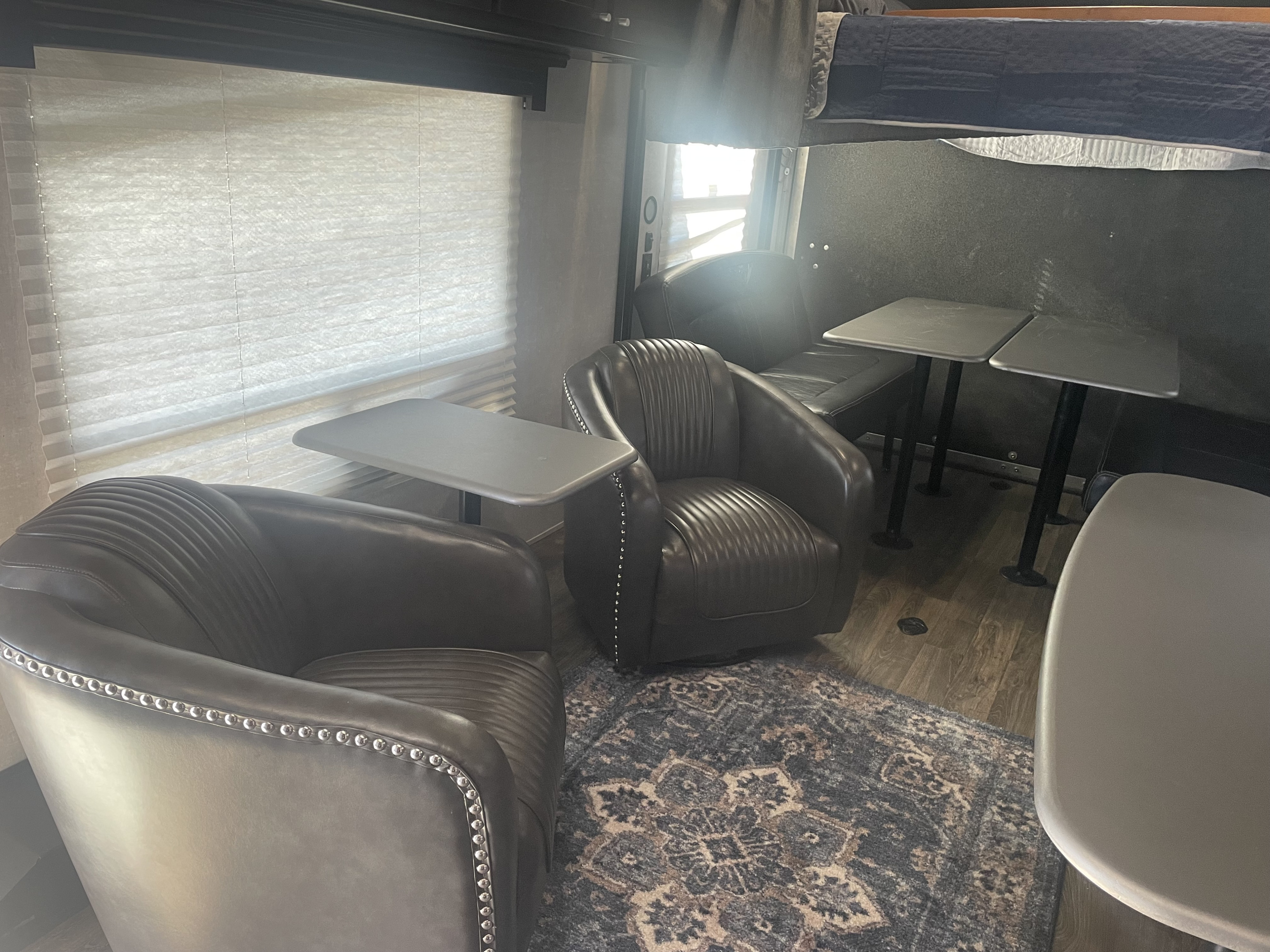 RV rental: Cozy interior with two brown leather armchairs, tables, and a bunk bed visible above.. Eclipse Attitude Pro Lite Toy Hauler 2019