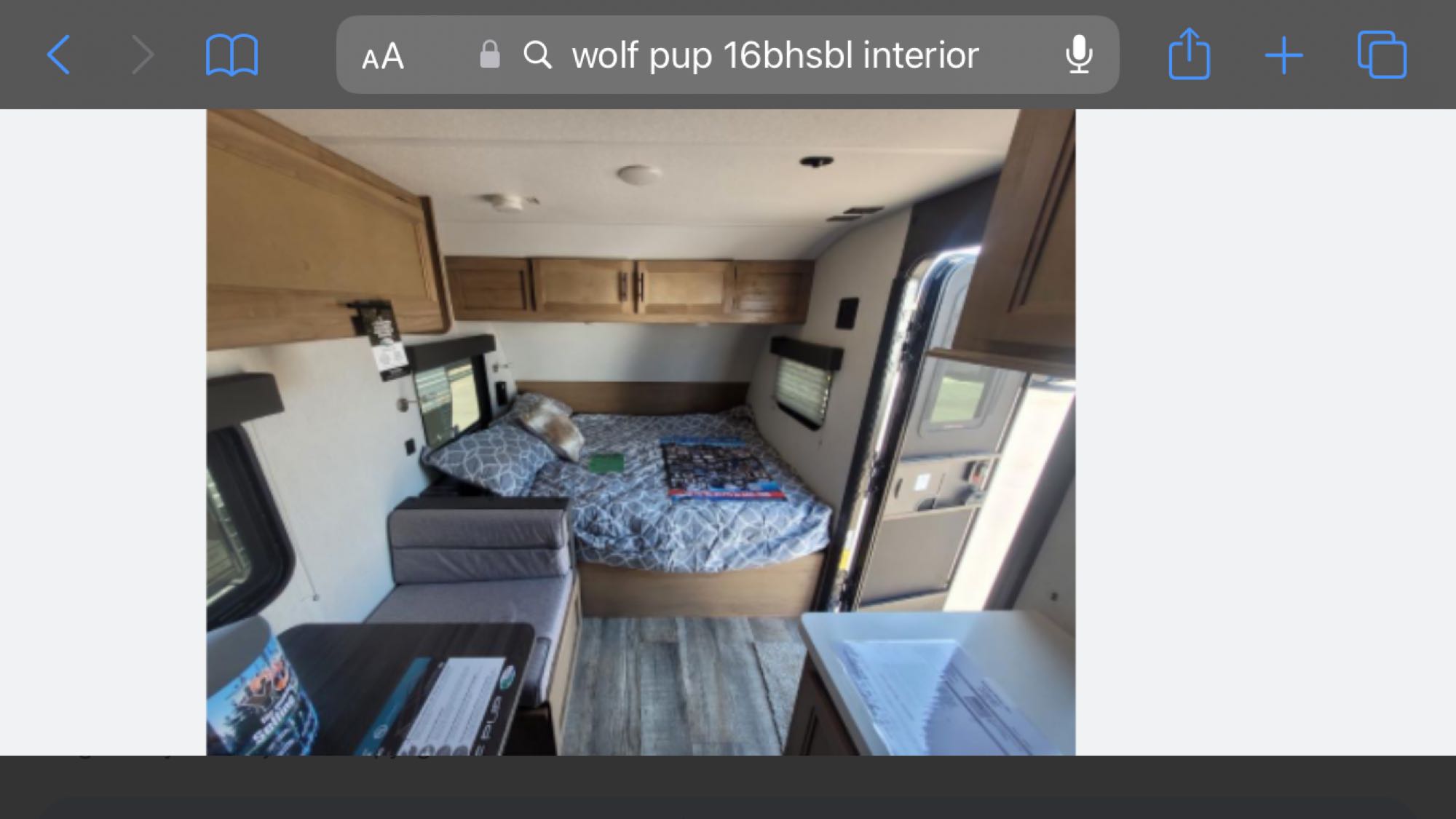 RV rental: Wolf Pup 16bhsbl travel trailer interior. Features a compact bed, dinette, & overhead storage.. Forest River Wolf Pup 16BHS BL 2024