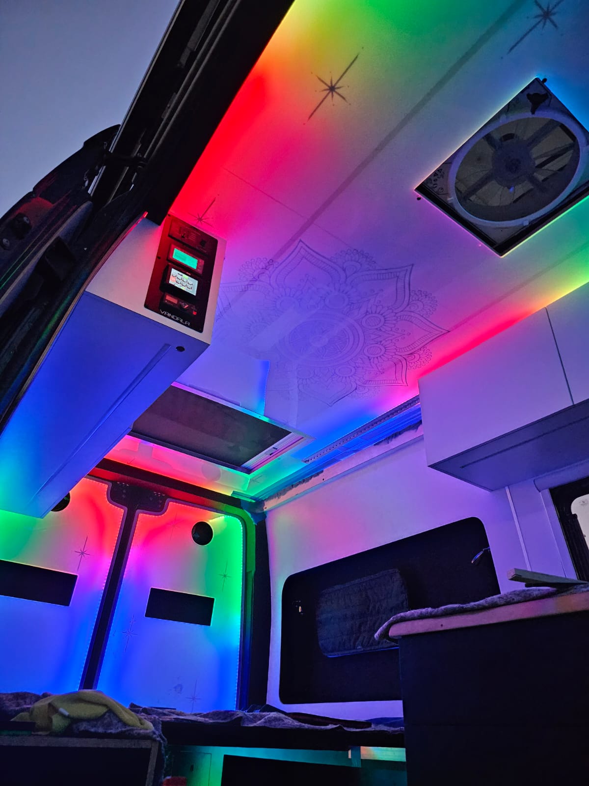 Experience a vibrant RV rental! This custom camper van interior features colorful LED lights, a mandala ceiling, and a sleek control panel.. Mercedes-Benz Sprinter 144 High Roof 2022