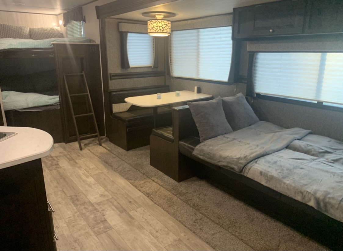 Cozy rv rental interior showcasing bunk beds, dinette, and sofa bed. Perfect for family adventures.. Heartland Pioneer 2020