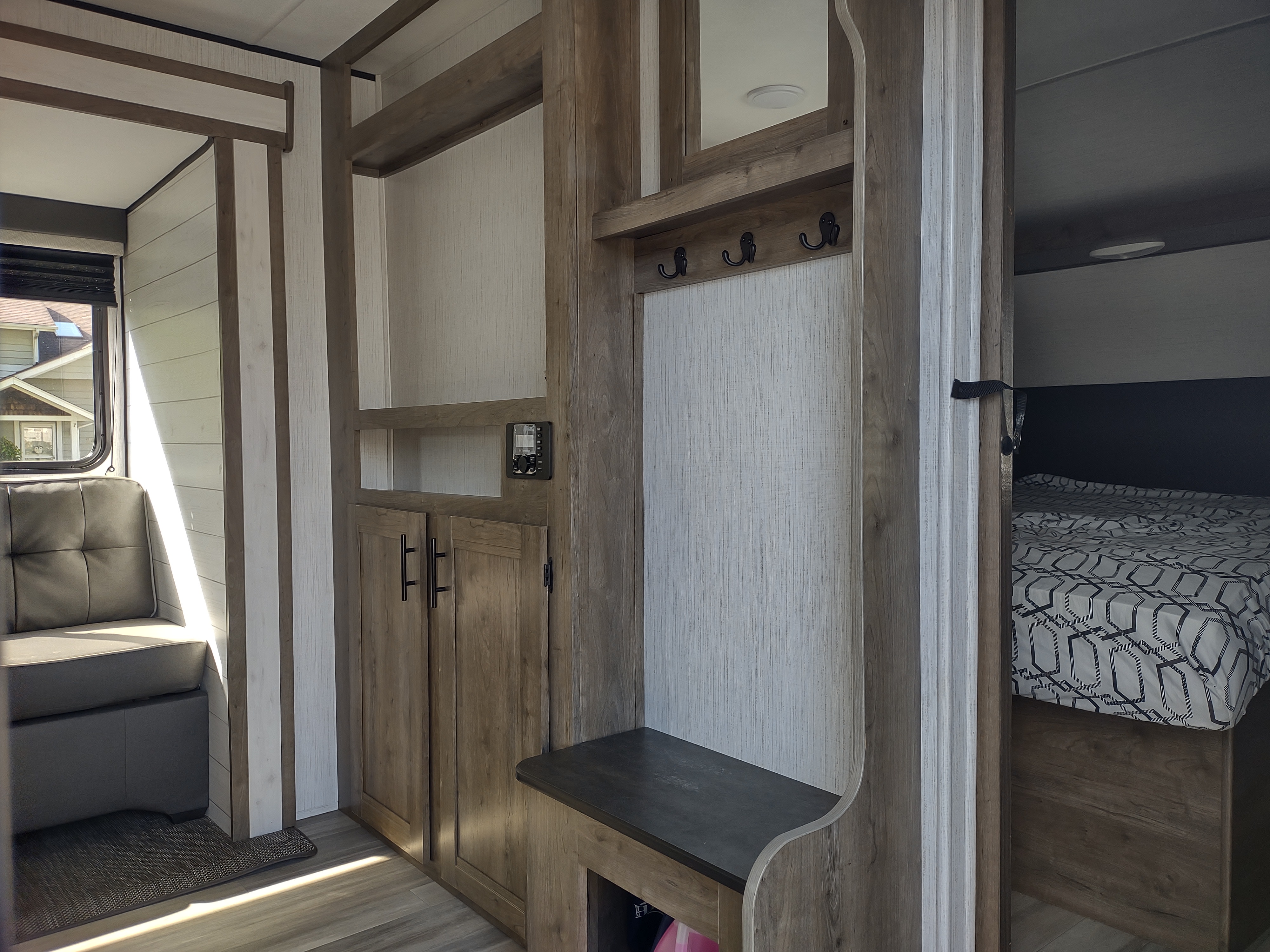 Spacious RV rental interior featuring a cozy living area, built-in storage, and a glimpse into the comfortable bedroom.. Heartland RVs Pioneer 2021