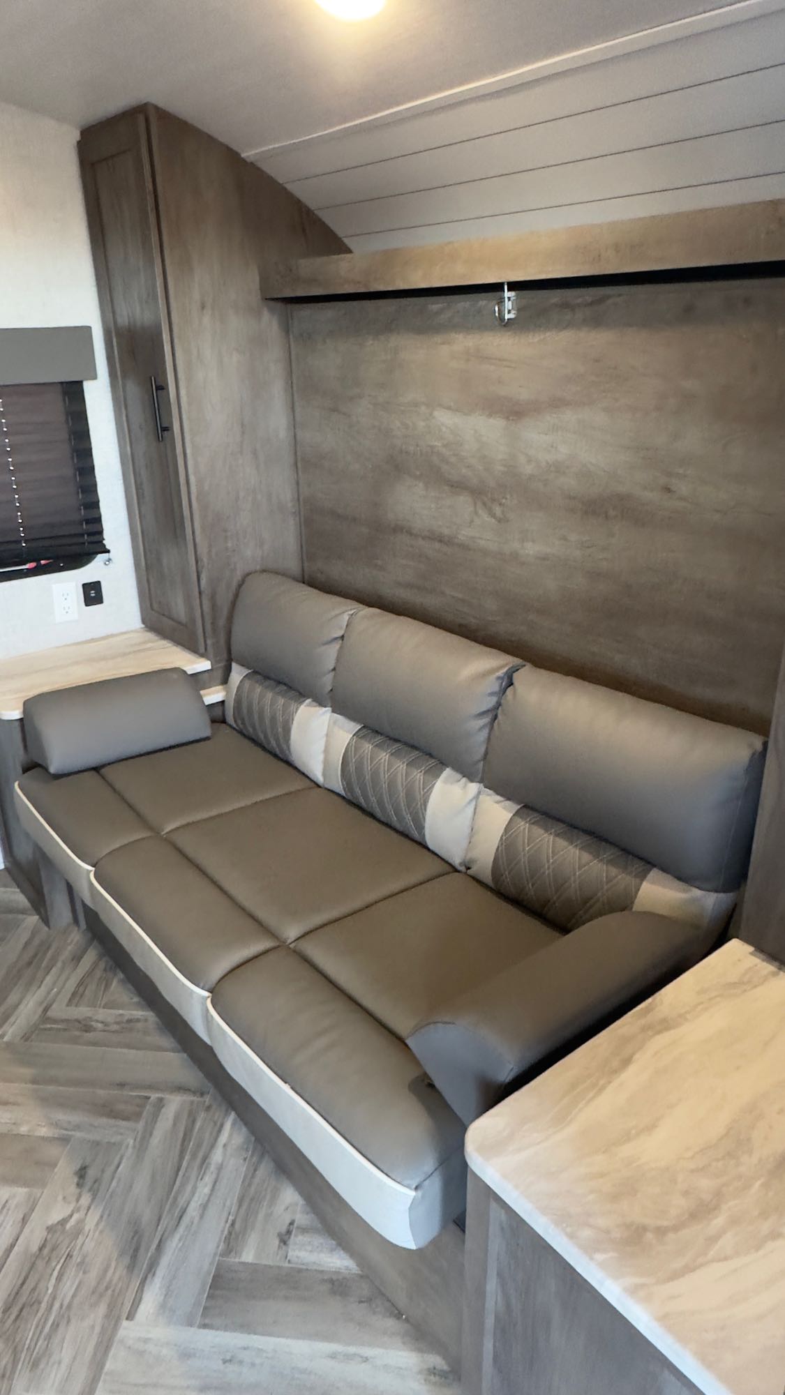 RV rental: Modern gray sofa converts to a bed in this compact interior with wood-look floors.. Forest River Wildwood X-Lite 2021