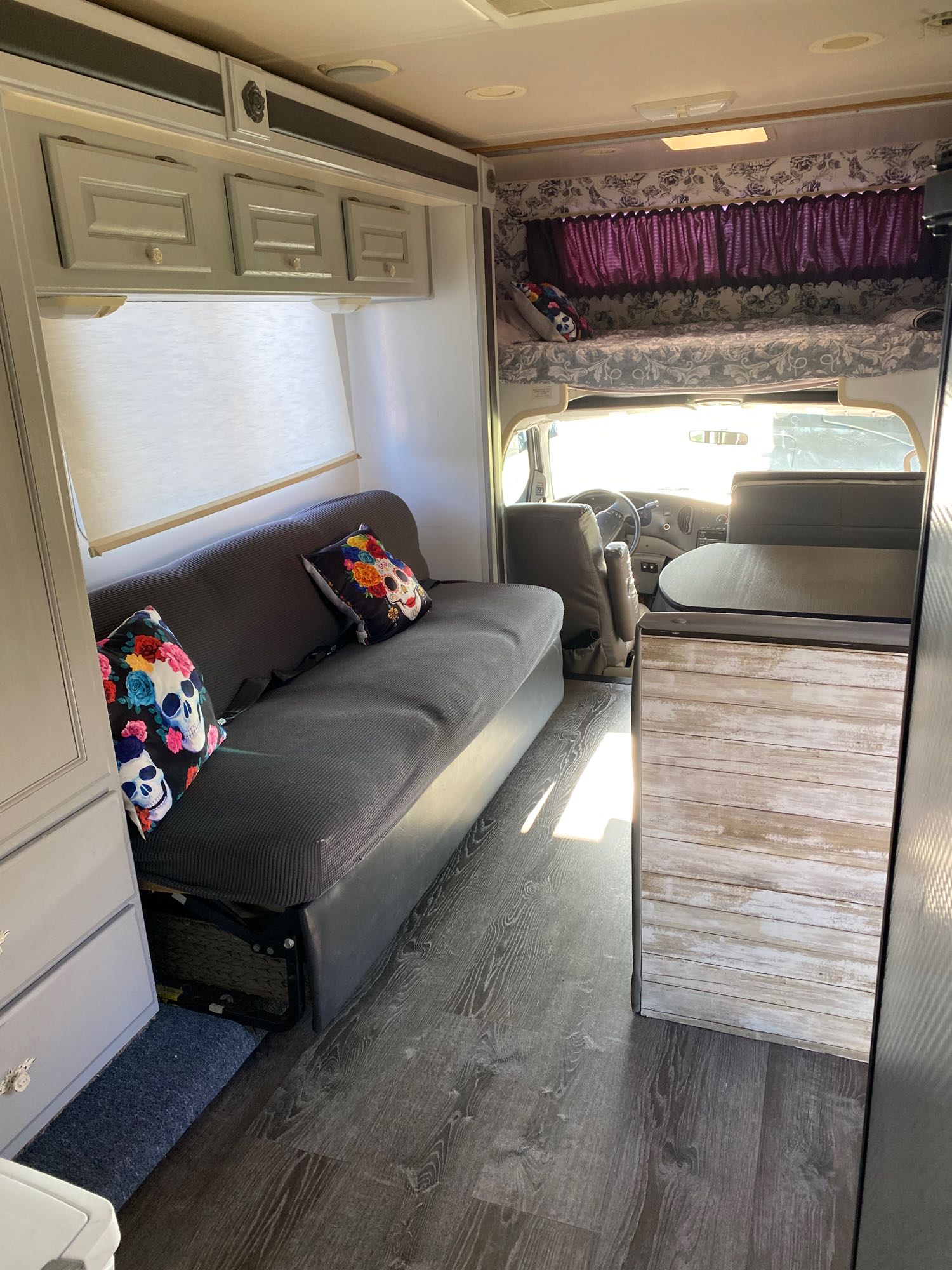 Spacious RV rental interior, showcasing a sofa, overhead storage, front bunk bed, and the driver's cabin.. Holiday Rambler Atlantis 2002