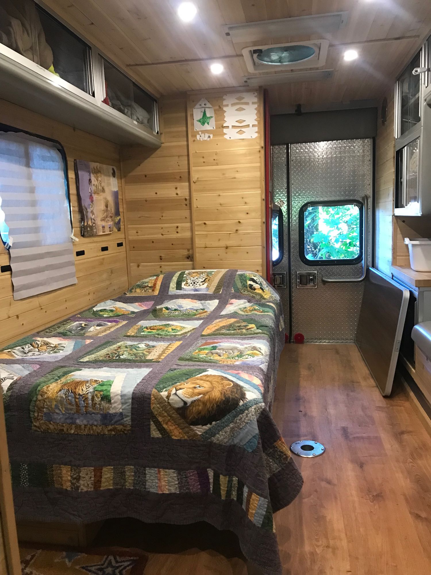 Inside this charming RV rental: a bed with an animal quilt, wood-paneled walls, and built-in storage.. Ford E450 2004