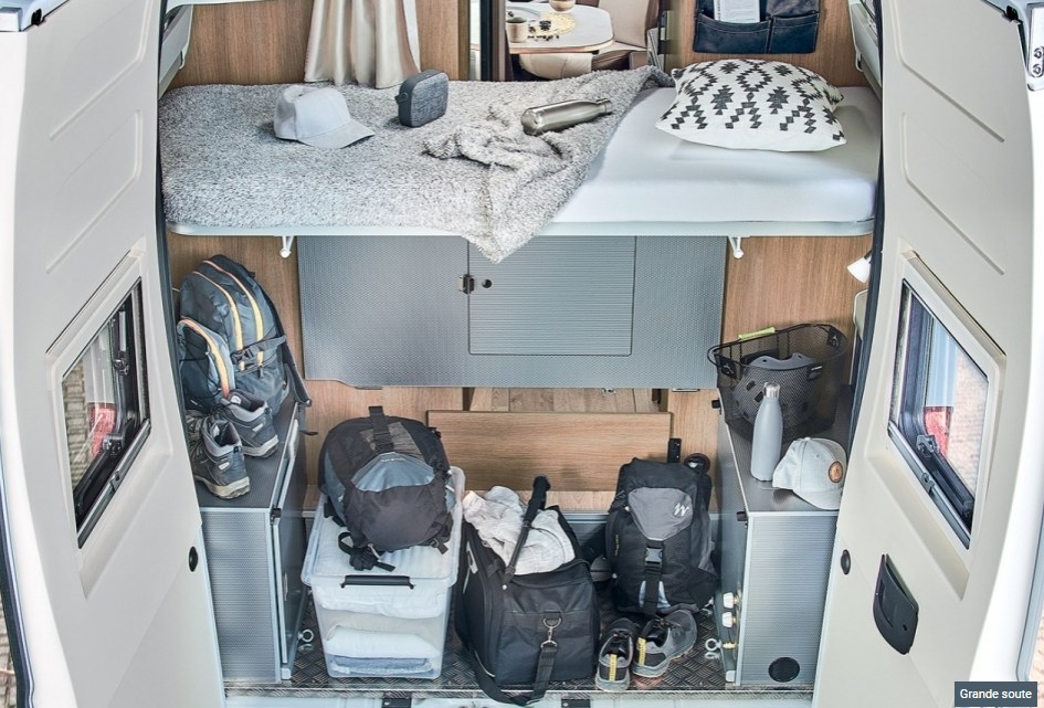 RV rental camper's rear interior: compact bed above organized storage for travel gear & essentials.. CAMPEREVE FAMILY VAN 2022