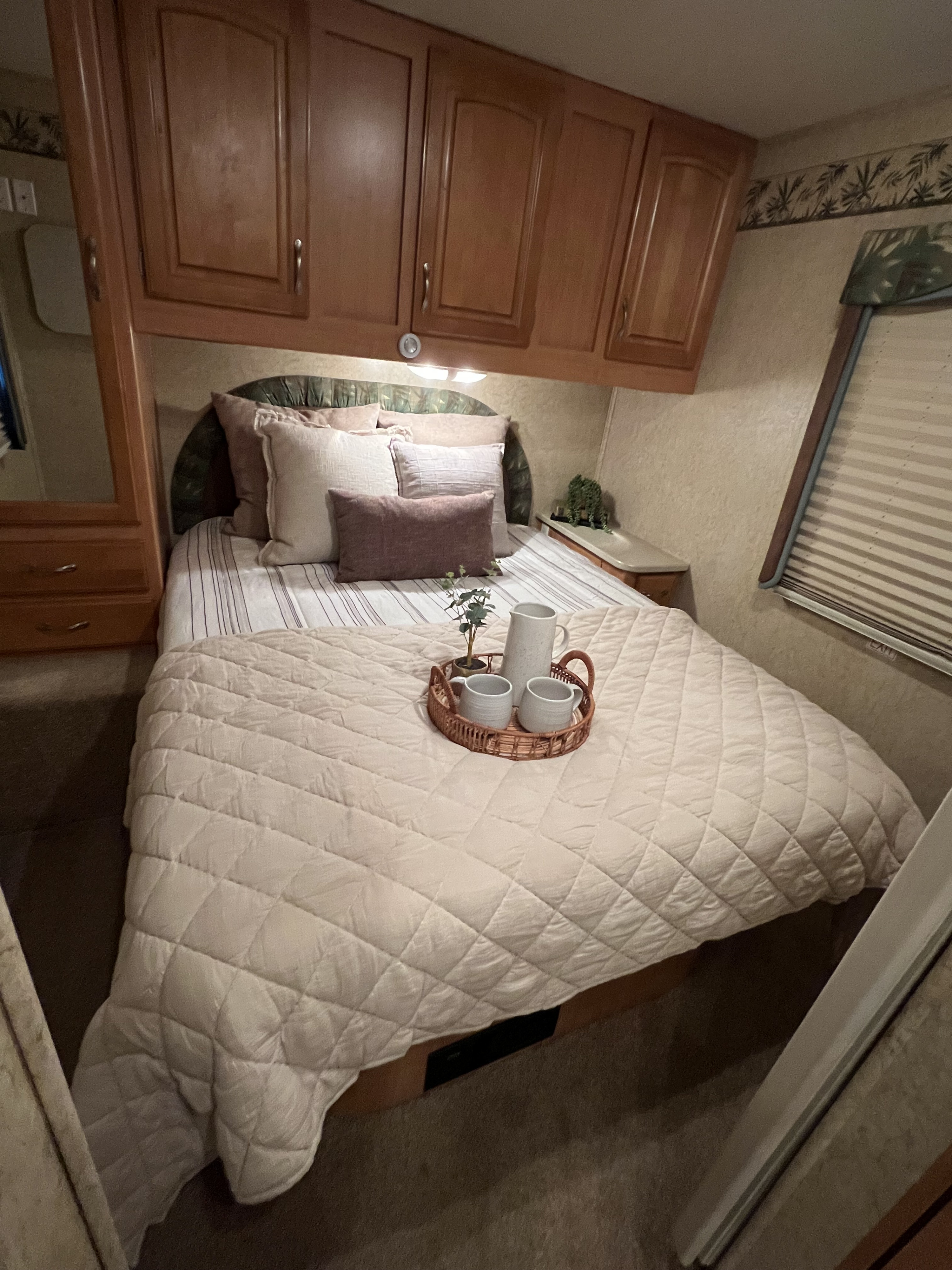 This cozy RV rental features a comfortable bedroom with overhead storage, ready for a restful stay.. Jayco Greyhawk Sport 2008