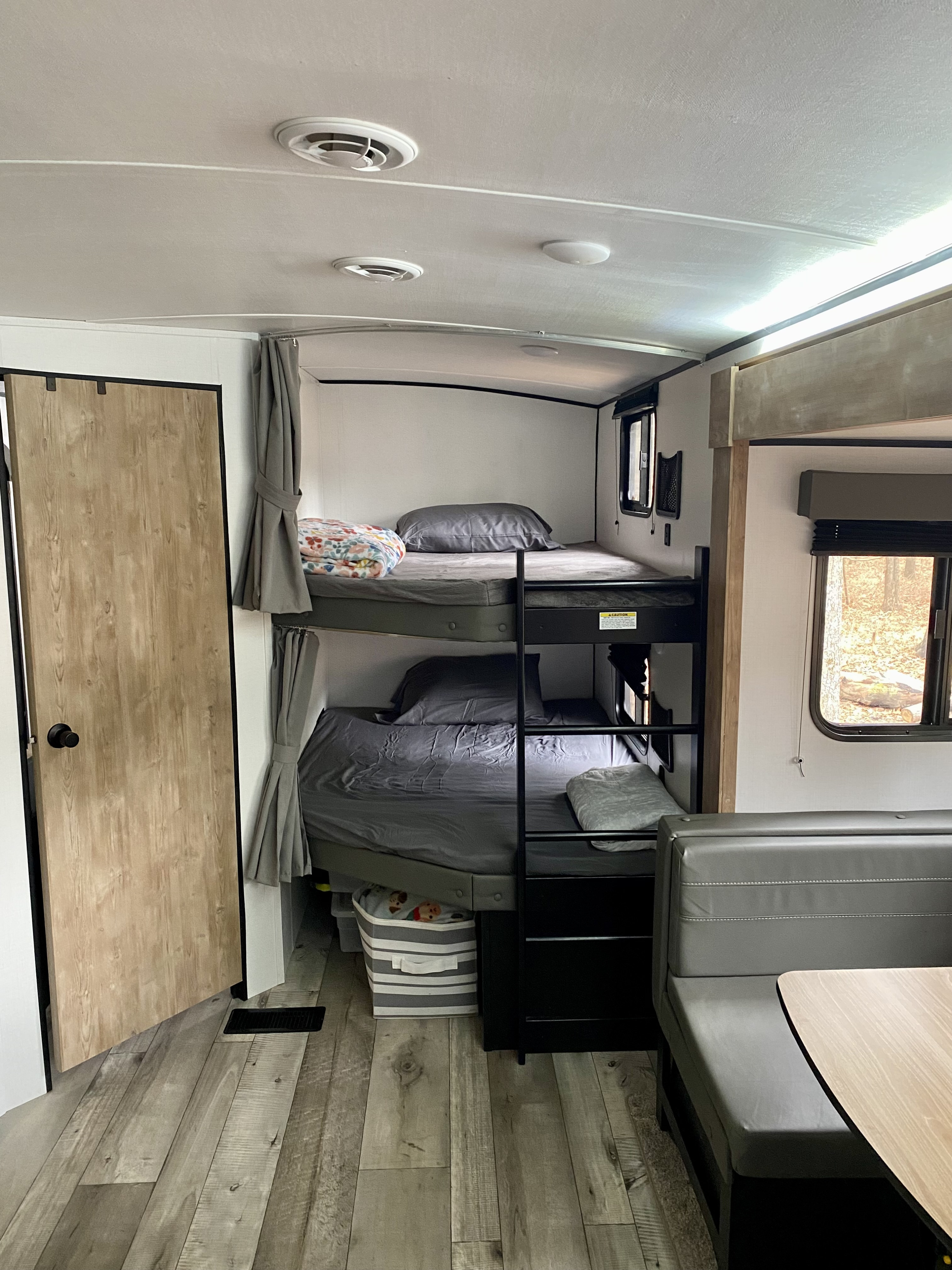 Cozy RV rental interior with bunk beds and a dining area, perfect for family adventures.. Keystone RV Springdale 2022