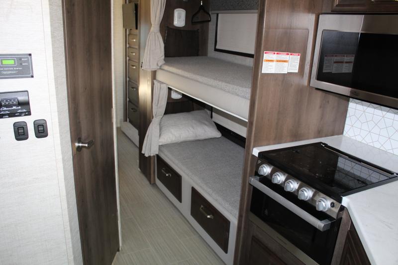 This RV rental interior features bunk beds, a kitchen with stove/microwave, and a control panel for comfortable travels.. Entegra Coach Esteem 2022