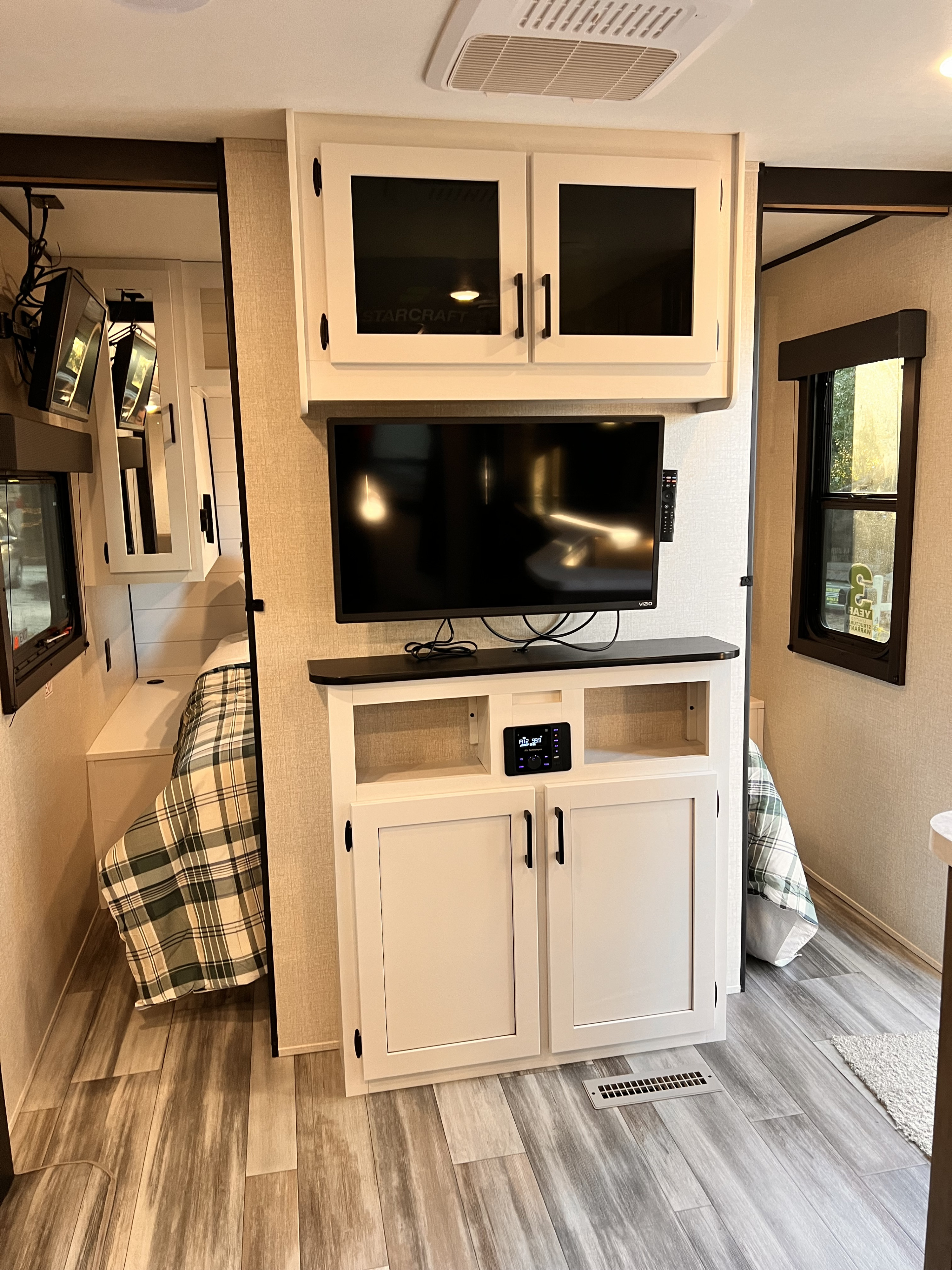 Modern rv rental interior showcasing an entertainment center, TV, stereo, and a cozy bedroom nook.. Starcraft Autumn Ridge 2024