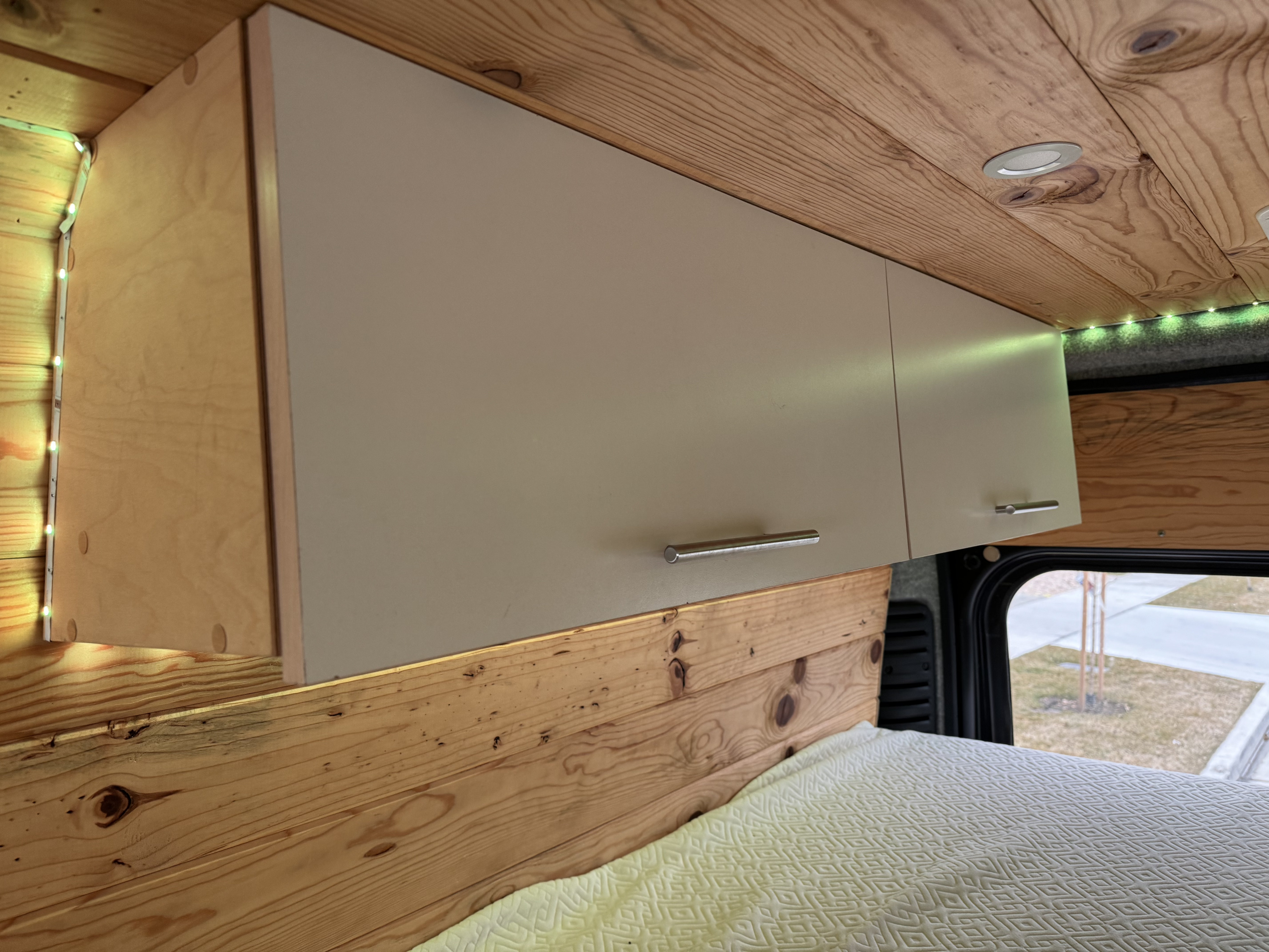 Cozy RV rental interior with custom wood, ambient lighting, and overhead cabinets for comfortable travel.. Ram Promaster 2500 2020