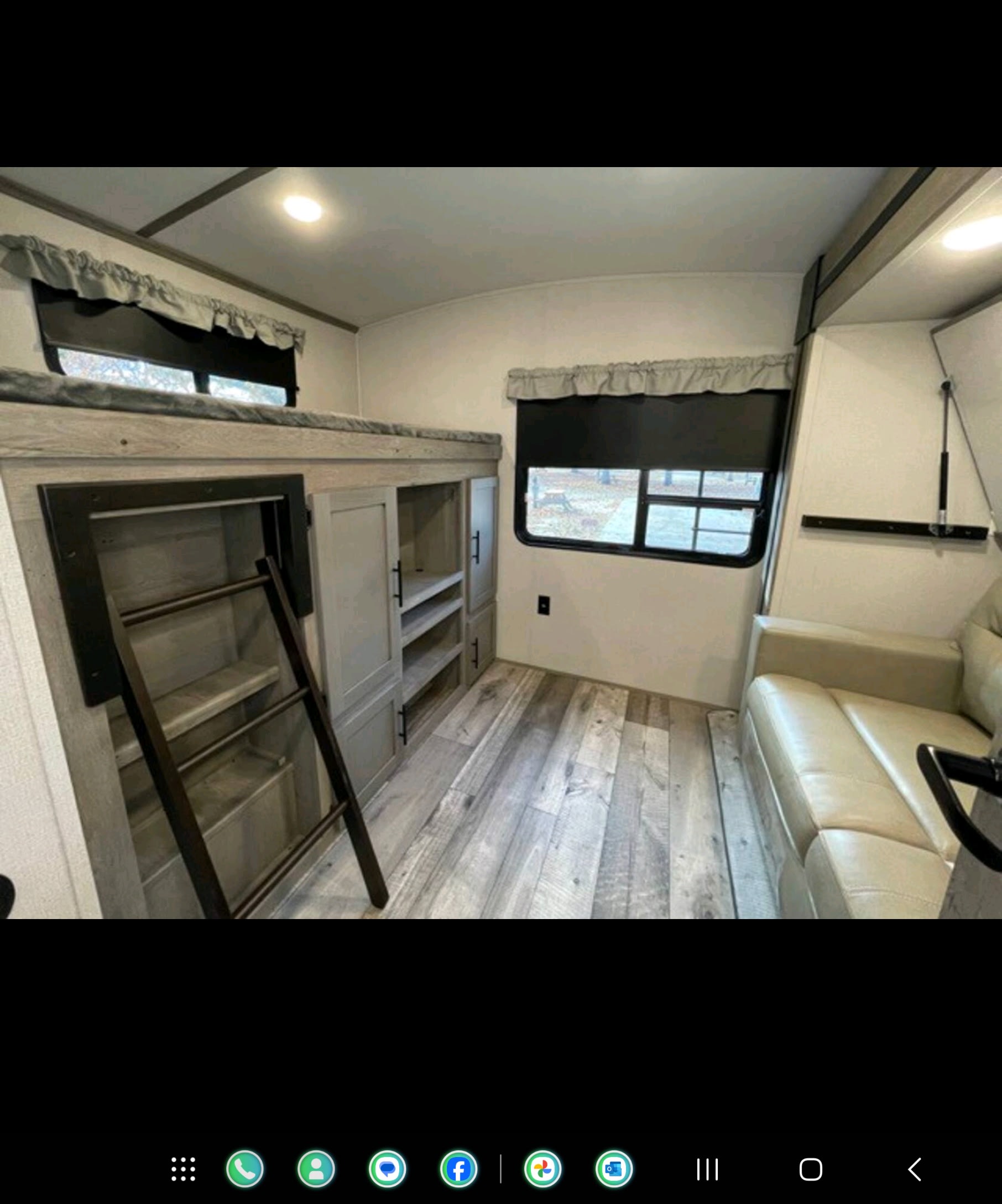 Spacious RV rental interior with bunk bed, ladder, storage, sofa, and window. Perfect for comfortable travel.. Keystone Outback 2022
