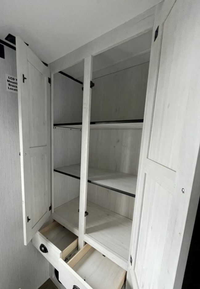 RV rental storage: White cabinet with open shelves & drawers. Ideal for organizing your travel items.. Heartland RVs Trail Runner 2022
