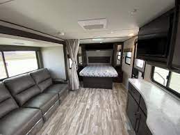 Spacious, modern RV interior with living area, kitchen counter, and bedroom. Perfect for your next comfortable RV rental travel.. Grand Design Transcend Xplor 2021
